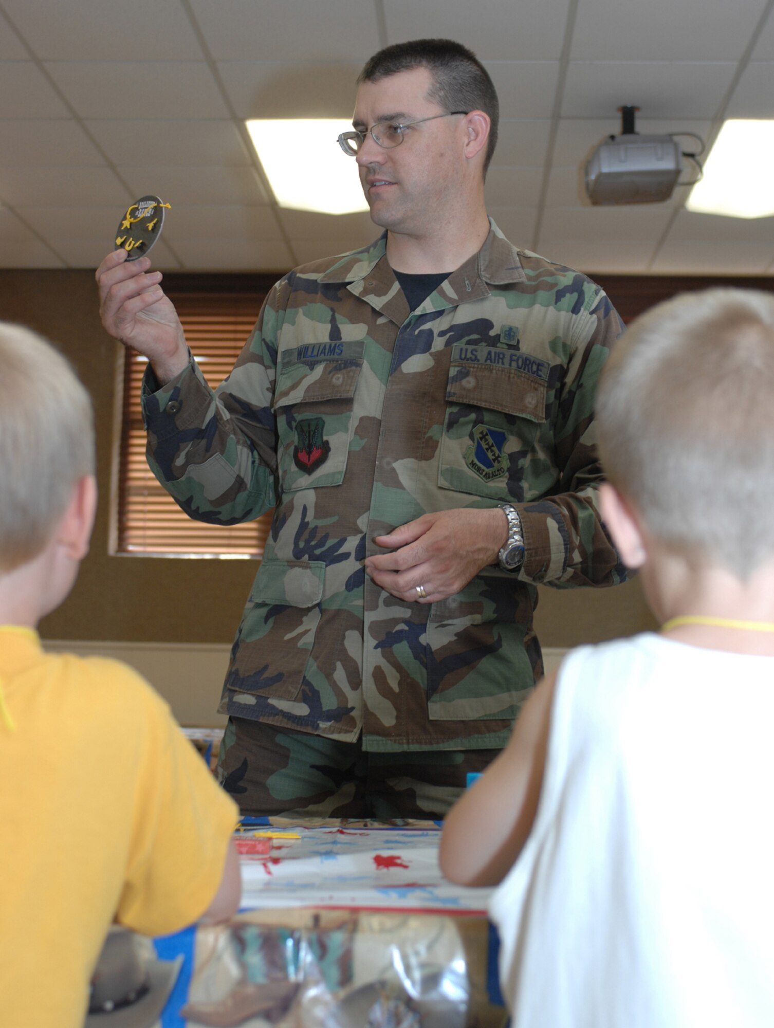 DYESS AIR FORCE BASE, Texas -- Tech. Sgt. Jack Williams, 7th Medical Group, teaches children at the base chapel's Vacation Bible School how to make the craft of the day June 6. (U.S. Air Force photo by Airman First Class Jennifer Romig)