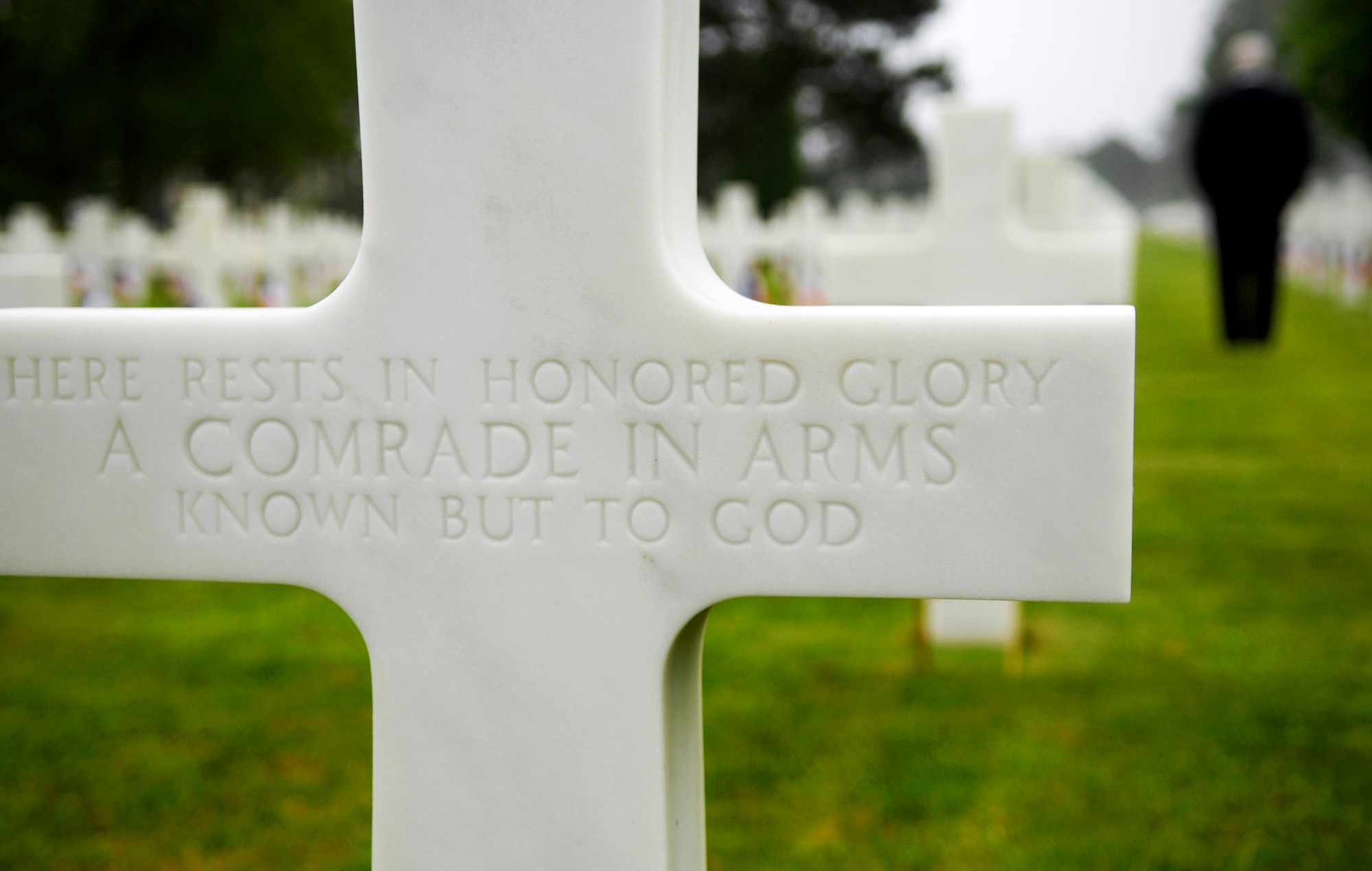 A cross marks the grave site for an unknown Soldier as Secretary of Defense Robert M. Gates tours the American Cemetery during the 63rd Anniversary of D-Day June 6 in Normandy, France. (Defense Department photo/Cherie A. Thurlby) 
