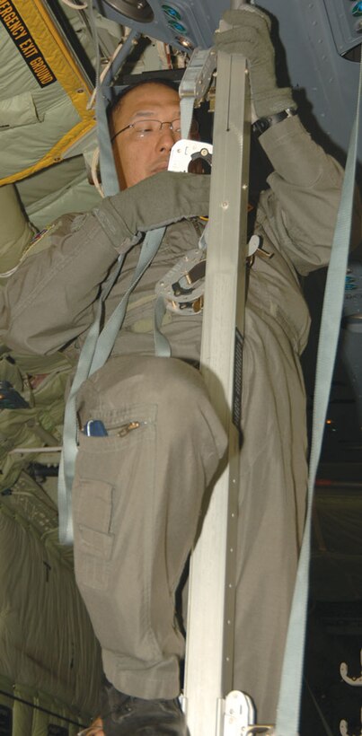 Maj. Ronald Deregla, a flight nurse with the 433rd AES, climbs a stantion to loosen straps used to secure litters on the C-130J. This standard sized aircraft can accomodate 74 patients on litters while the C-130J-30 ?stretched? version can be configured for up to 97. (U.S. Air Force Photo/Tech. Sgt. James B. Pritchett)