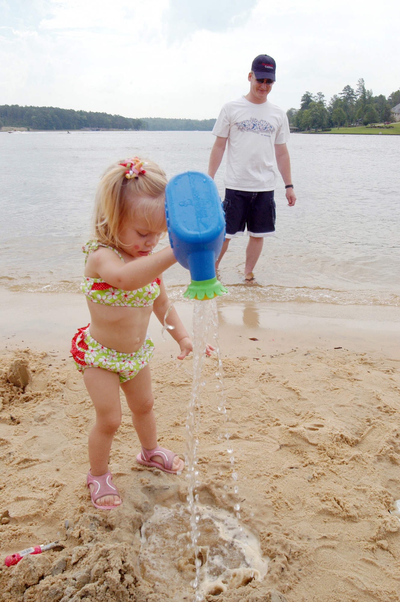 Maj. Donavan Kanak keeps a watchful eye on his daughter Rachel, 2, as she plays in the sand. U. S. Air Force photo by Sue Sapp 
