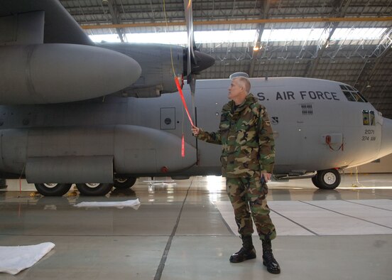 Col. Michael Riddle inspects a propeller of a C-130 Hercules. Colonel Riddle will relinquish command to Col. Gerald Frisbee at 9 a.m. June 14 at the Yokota Enlisted Club. (Photo by Senior Airman Veronica Pierce 070207-F-3177P-001)