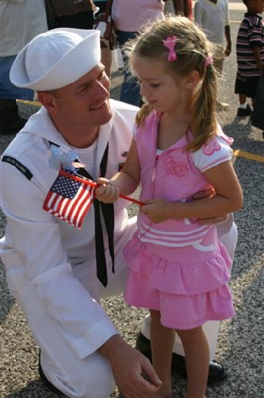 Petty Officer 1st Class David Couch greets his four-year-old daughter as he returns from a deployment aboard the guided-missile destroyer USS The Sullivans (DDG 68) to Mayport, Fla., on May 29, 2007.  