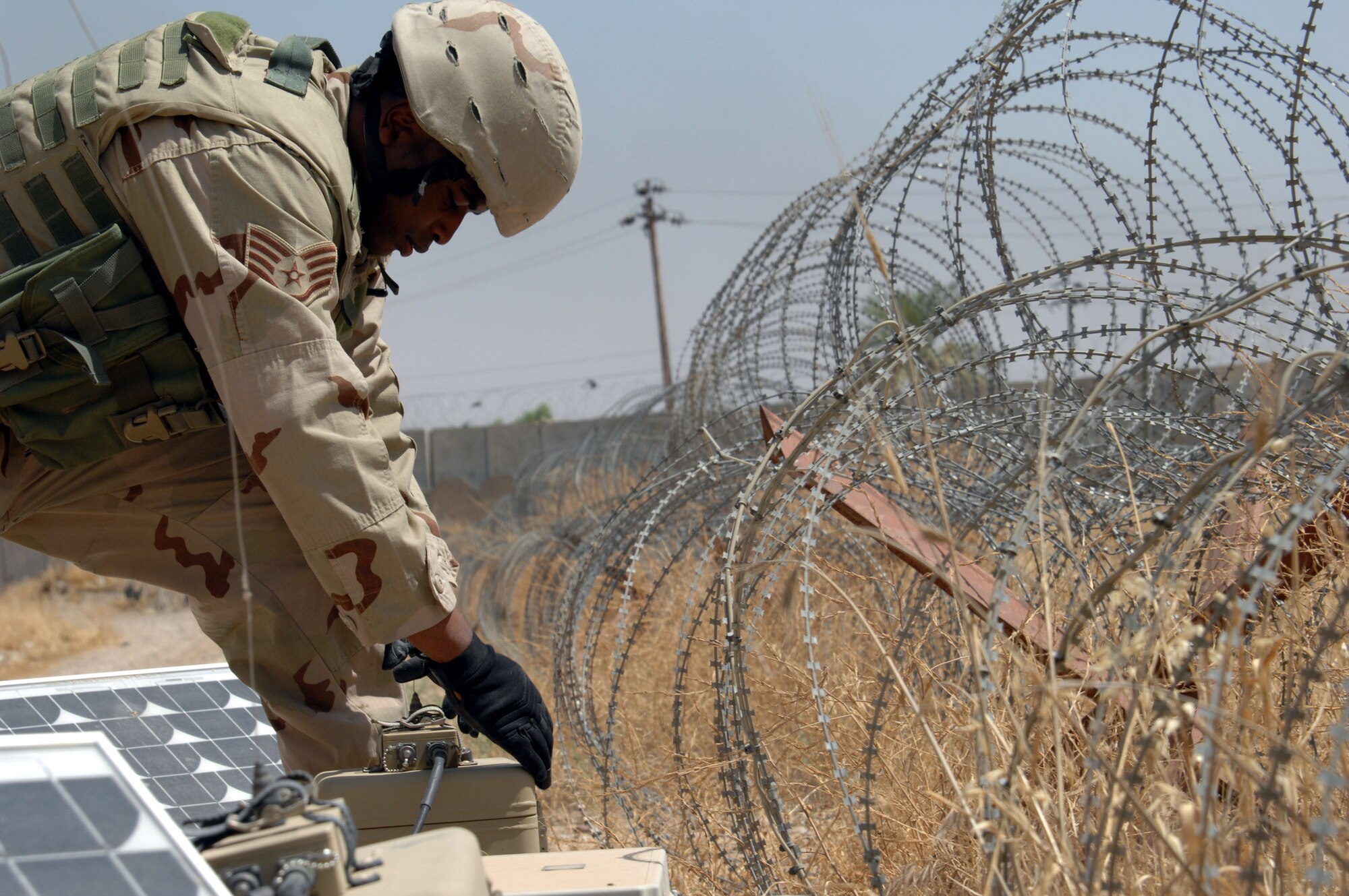 Staff Sgt. Anthony Chambers checks a solar-powered security system May 30 at Kirkuk Air Base, Iraq.  Sergeant Chambers is deployed to the 506th Expeditionary Security Forces Squadron.  (U.S. Air Force photo/Senior Airman Kristin Ruleau)