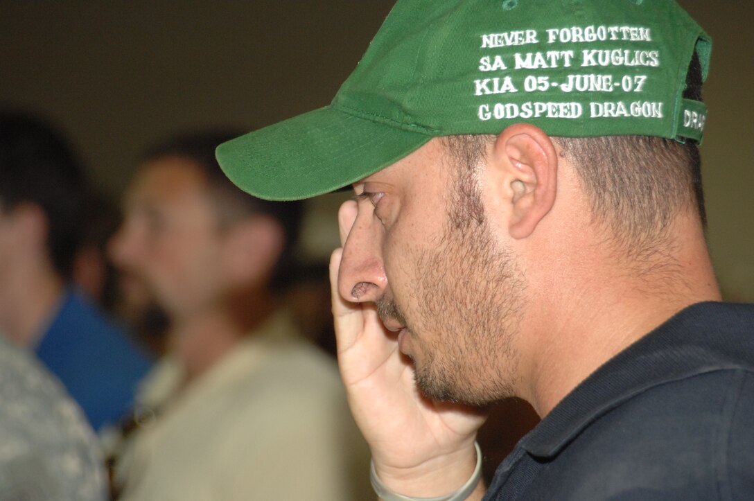 Special Agent Ryan Smith, Air Force Office of Special Investigations, Expeditionary Detachment 2411, Balad Air Base, Iraq, salutes during a memorial ceremony honoring Special Agents Ryan Balmer and Matthew Kuglics at Kirkuk Regional Air Base, Iraq, June 8, 2007. The agents were killed in action June 5 while supporting Operation Iraqi Freedom. Agent Smith's hat is embroidered in tribute to his lost friend, Agent Kuglics. (U.S. Air Force photo/ Senior Airman Kristin Ruleau)