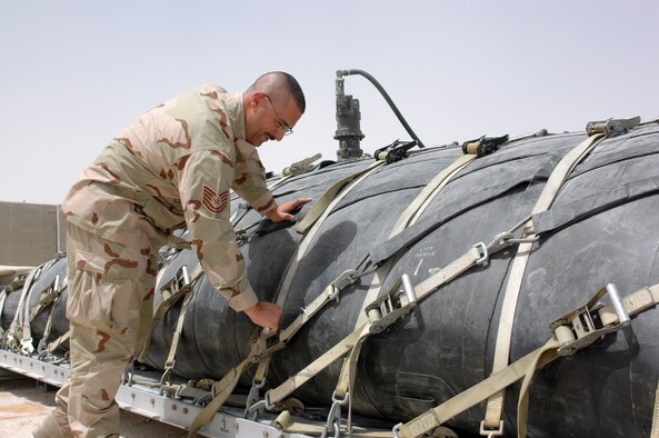 Tech. Sgt. John Kiniry, 379th Expeditionary Logistics Readiness Squadron, checks to make sure a fuel bladder is properly fastened. Fuel bladders hold about 200,000 gallons each and there are 38 bladders here. About 15 million gallons of fuel are stored on base and 1 million gallons are delivered by day. 