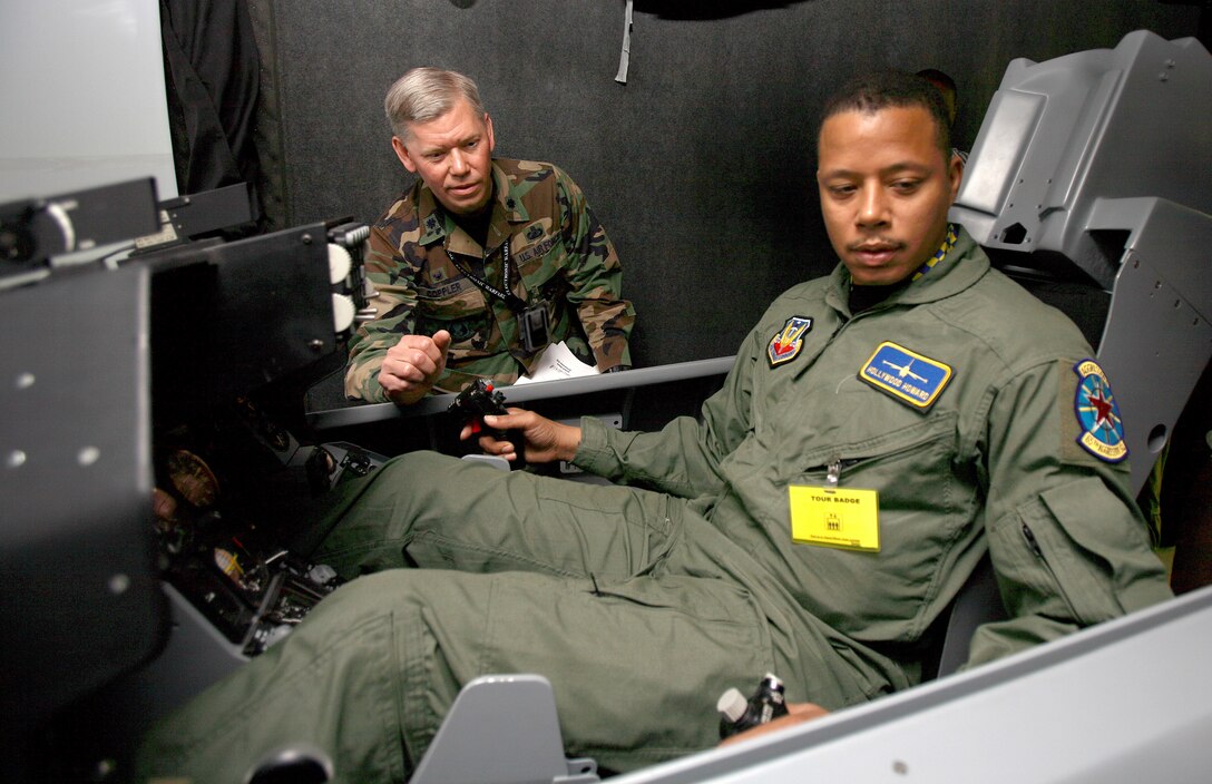 Air Force Lt. Col. David Coppler, 772nd Test Squadron commander, instructs actor Terrence Howard on the controls of an F-16 Fighting Falcon simulator at Edwards Air Force Base, Calif., to help prepare Howard for his role in the movie, “Iron Man.” Photo by Jet Fabara