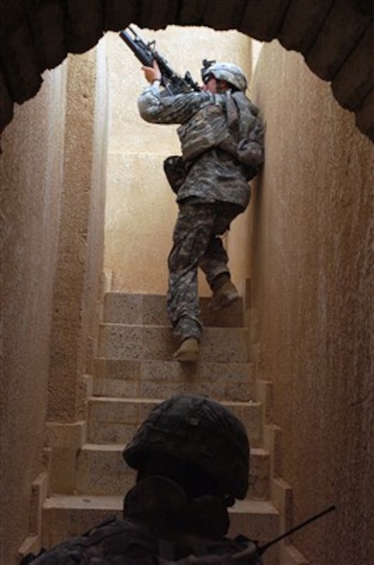 A U.S. Army soldier from Bravo Battery, 1st Battalion, 319th Field Artillery Regiment, 82nd Airborne Division clears the rooftop of a house during a search for insurgent forces in Owja, Iraq, on May 31, 2007.  