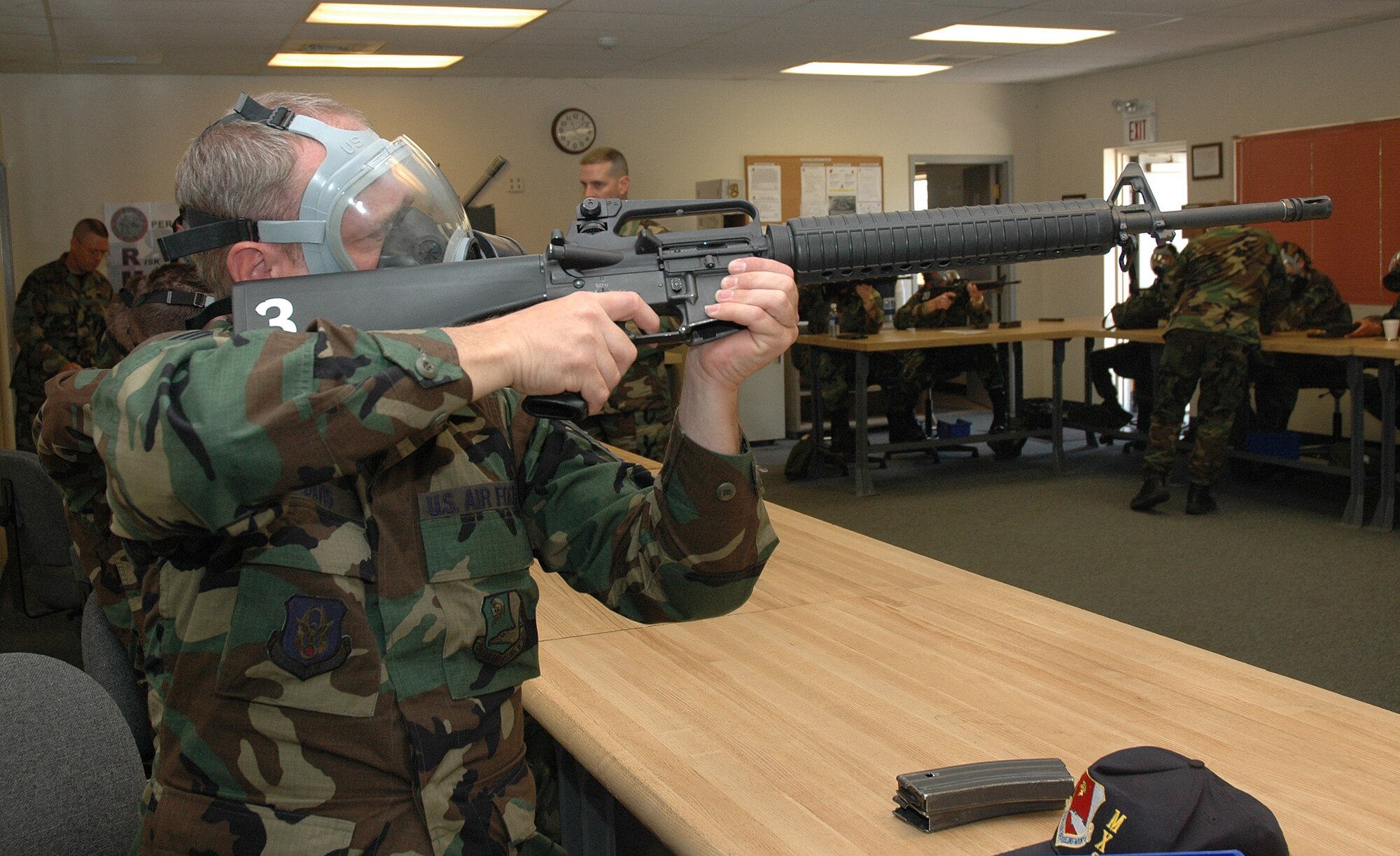 Air Force reservist Staff Sgt. Jonathan Davis Jr., a metals technician with the 940th Maintenance Group, practices sighting an M-16 with a gas mask on. He and other unit members from the 940th Air Refueling Wing recieved classroom instruction for M-16 weapons qualification shoot during a Unit Training Assembly weekend at Beale Air Force Base, Calif. in preparation for an Operational Readiness Inspection in February 2008. (U.S. Air Force Photo/ Staff Sgt. Luke Johnson)