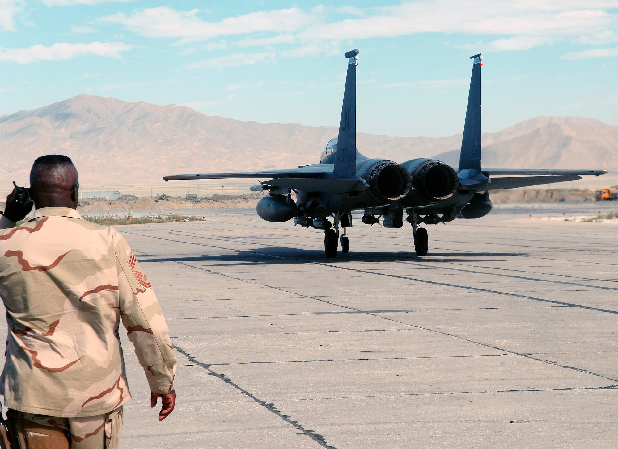 Chief Master Sgt. Ezell Buxton, 455th Expeditionary Maintenance Group chief enlisted manager, watches as an F-15E assigned to the 492nd Expeditionary Fighter Squadron taxis off the Alpha taxiway at Bagram Airfield, Afghanistan June 9. Chief Buxton is deployed from Davis-Monthan Air Force Base, Ariz. (photo by Staff Sgt. Craig Seals)