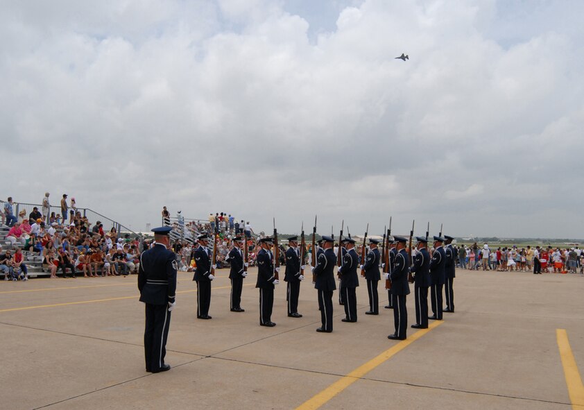 TINKER AFB, Okla. - A F-16 jet flies overhead as the Air Force Honor Guard Drill Team performs at Tinker AFB's Star Spangled Salute. The Drill Team is the traveling component of the Air Force Honor Guard and tours Air Force bases world wide showcasing the precision of today's Air Force to recruit, retain, and inspire Airmen for the Air Force mission. (U.S. Air Force Honor Guard photo by Senior Airman Nestor Bauer)(Released)