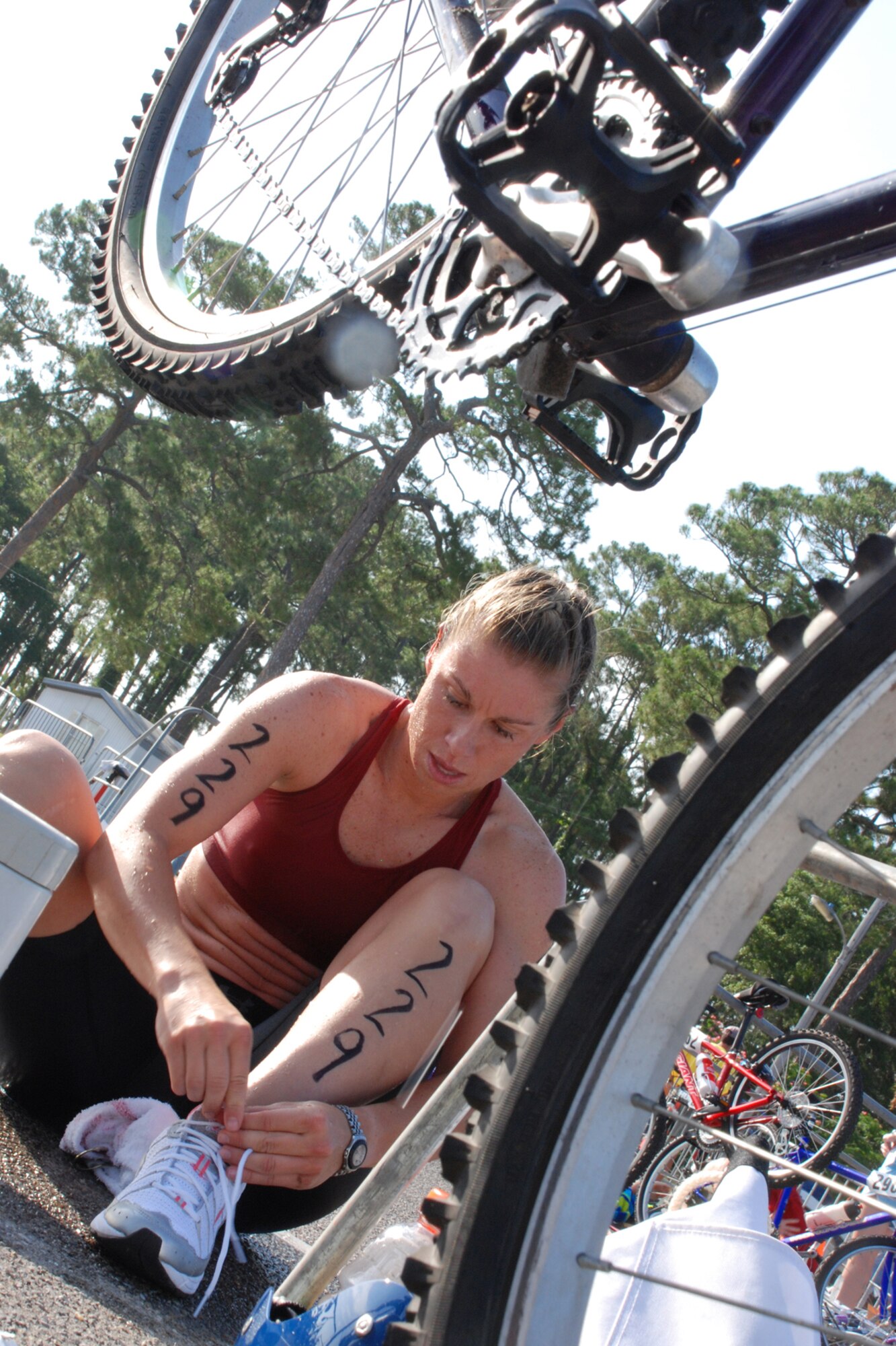 EGLIN AIR FORCE BASE, Fla. -- Andrea Lynch, of Crestview, Fla., ties her shoes preparing for the bike ride at the 8th Annual My First Tri triathlon at Post'l Point June 9. The triathlon featured a 200-meter swim, 8-mile bike ride and 2.5-mile run. A total of 150 out of the 248 triathletes were participating in their first triathlon. (U.S. Air Force Staff Sgt. Mike Meares)