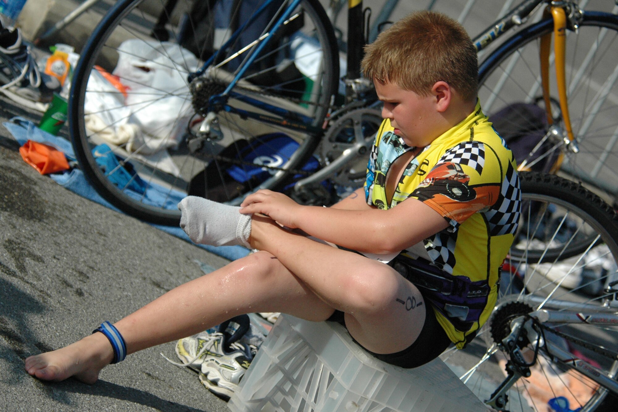 EGLIN AIR FORCE BASE, Fla. -- Nick Hopkins, 11, of Shalimar Fla., puts on his shoes after the 200-meter swim at the 8th Annual My First Tri triathlon at Post'l Point June 9. He had "Eat my bubbles...tread...dust" written in marker on his back and a reminder on his right arm that read "Keep Going." The triathlon featured a 8-mile bike ride and 2.5-mile run after the 200-meter swim. A total of 150 out of the 248 triathletes were participating in their first triathlon. (U.S. Air Force Staff Sgt. Mike Meares)