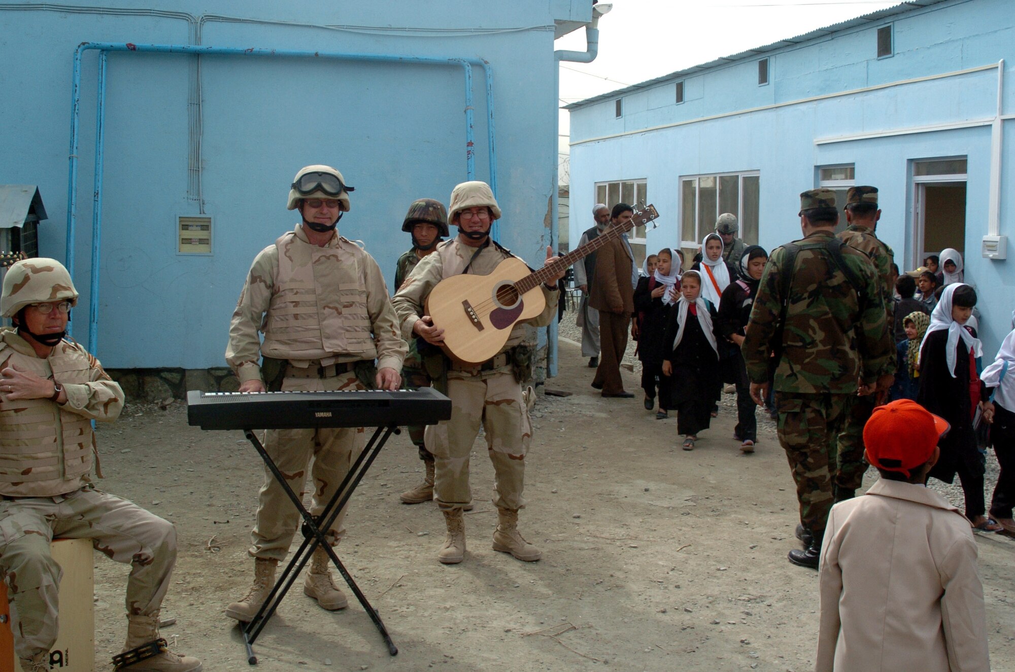 Chief Master Sgt. Larry MacTaggart, Senior Master Sgt. John Robert Henley and Tech. Sgt. David Foster, Air Force Band musicians, prepare for a Max Impact performance in a local village in Afghanistan. The audience was made up of family members of Afghan soldiers stationed in the area. (U.S. Air Force photo/Master Sgt. Regina Coonrod)