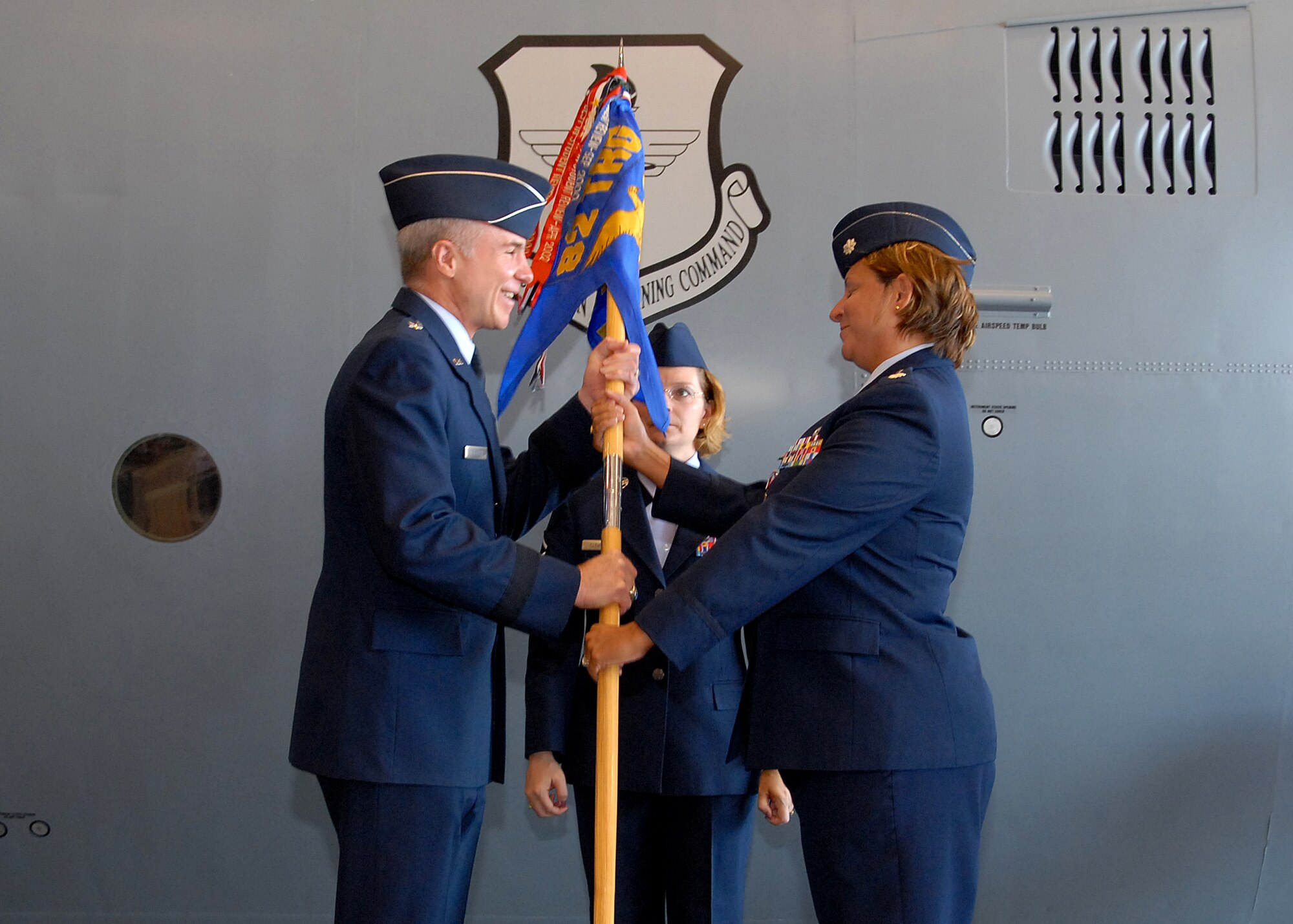 Lt. Col. Susan Santos hands off the guidon to Brig. Gen. Richard Devereaux during the 361st Training Squadron change-of-command ceremony June 11.  Colonel Santos passed on command of the 361st TRS to Lt. Col. Kelly Scott. (U.S. Air Force photo/Mike Litteken)