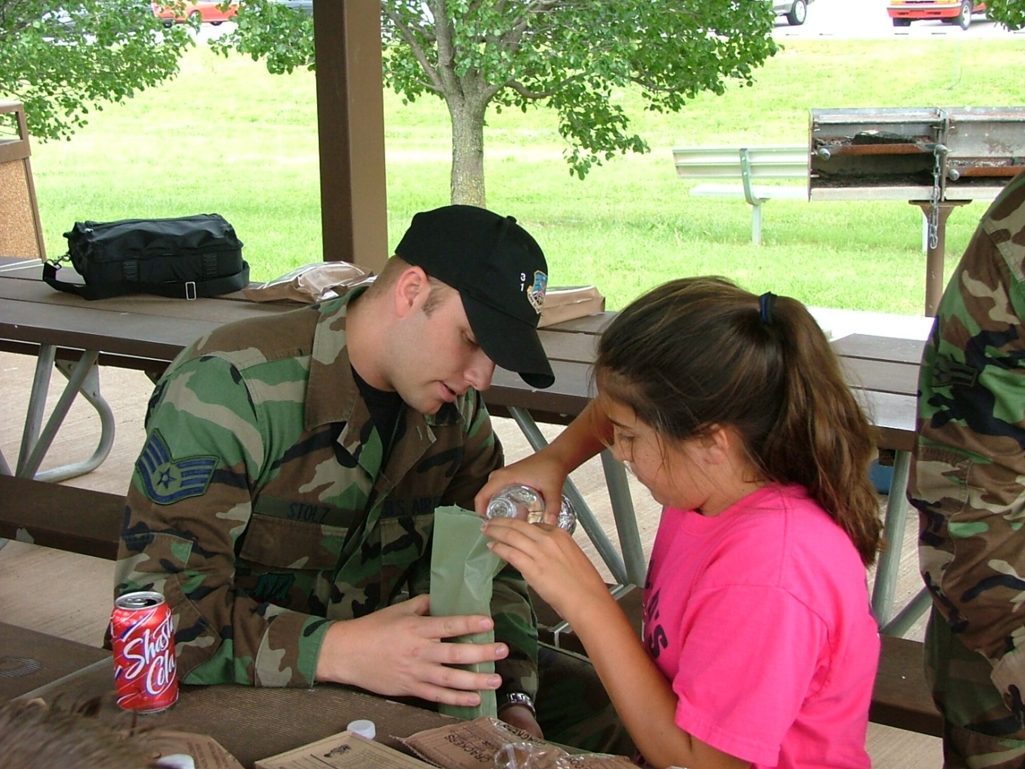 During the 3rd Herd Pen Pal visit the week of May 28, 31st Combat Communications Squadron member Staff Sgt. Benjamin Stolz helps his pen pal heat up her Meals Ready to Eat.