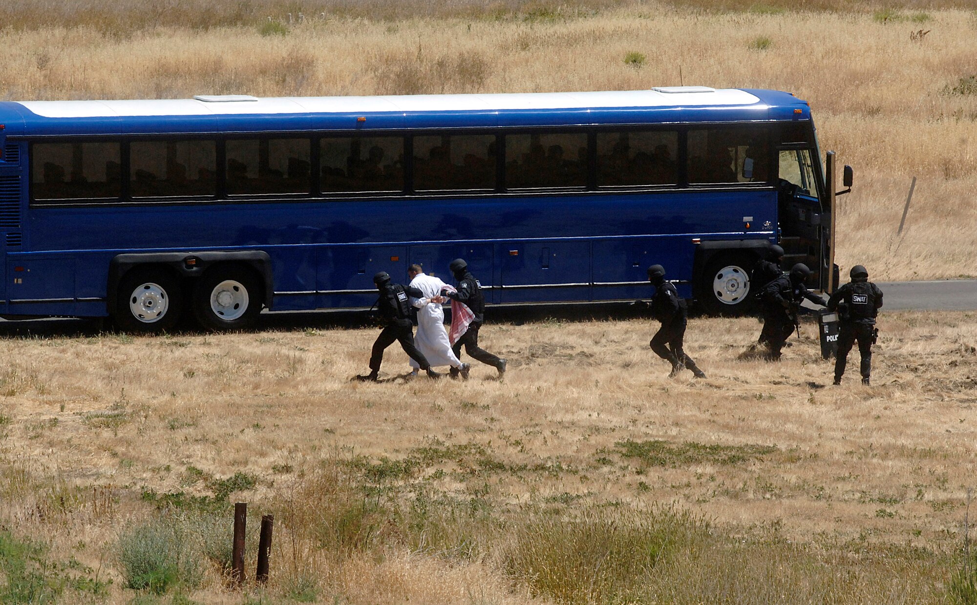 SWAT members capture a "terrorist" during a convoy attack scenario during an honorary commanders' tour June 7 during Air Force Week at Travis Air Force Base, Calif. The purpose of Air Force Week is to inform and educate the American public about the importance and roles of the Air Force in America's national defense. (U.S. Air Force photo/Tech. Sgt. Larry A. Simmons)