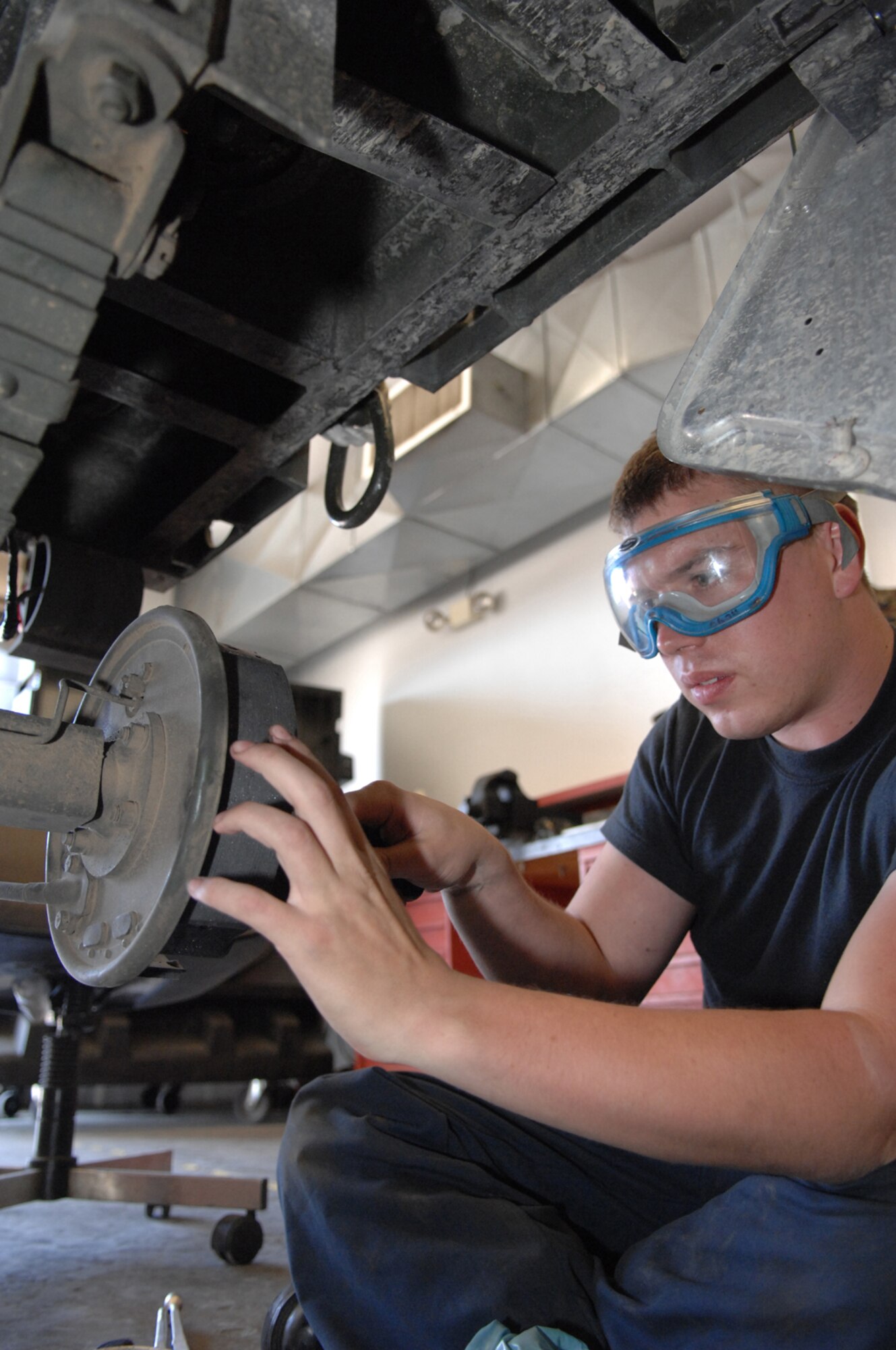Airman 1st Class Robert Burtis, a crew member assigned to the 57th Equipment Maintenance Squadron's Trailer Maintenance Flight, tightens up the brakes on a munitions carrier Tuesday May 15, 2007 at Nellis AFB, Nevada. The trailer maintenance fleet here is the largest in the Air Force, said Airman Burtis.(U.S Air Force Photo by/ Senior Airman Larry E. Reid Jr.)