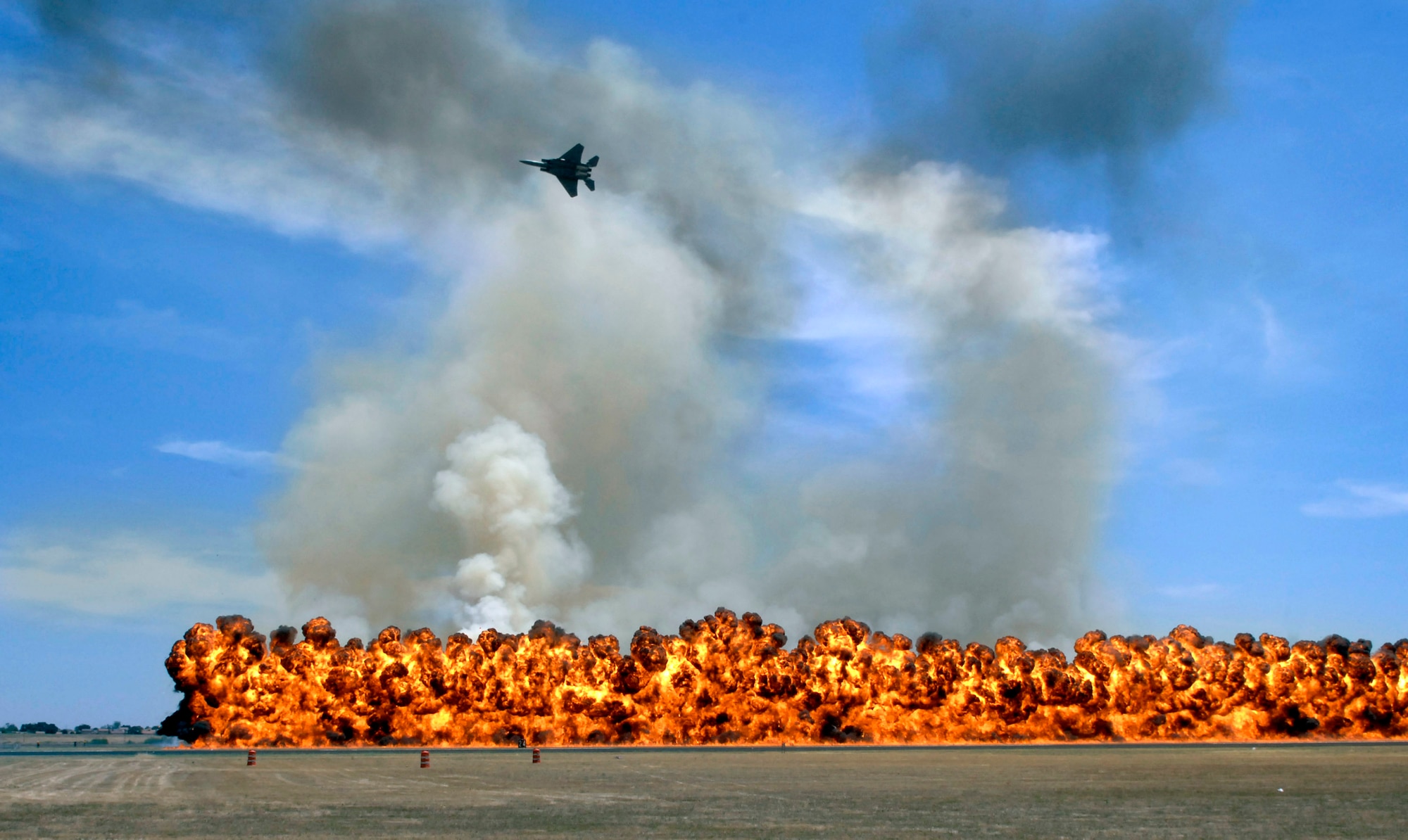 Pyrotechnics explode while an F-15 flies over to simulate an air-to-ground attack during the California Capital Air Show in Sacramento, Calif., on Jun. 9. The air show was the last event of Air Force Week California. The purpose of Air Force Week is to inform and educate the American public about the importance and roles of the Air Force in America's national defense. Over 50,000 people attended the air show featuring the Air Force Thunderbirds and numerous Air Force aircraft. (U.S. Air Force photo/Tech. Sgt. Larry A. Simmons)