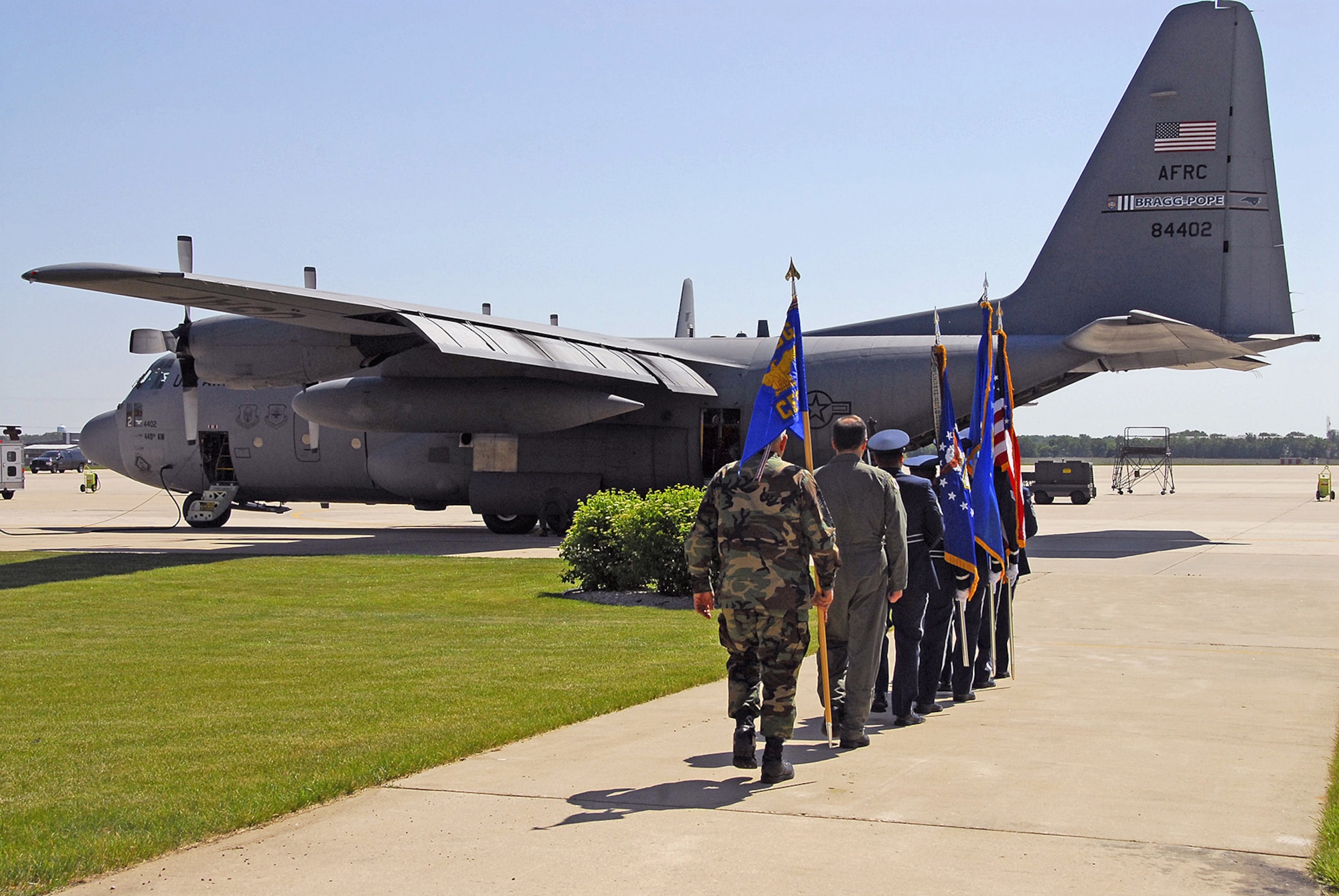 Col. Merle D. Hart, 440th Airlift Wing commander, and Chief Master Sgt. Carmon Francher, wing command chief master sergeant, follow the honor guard to a C-130 during the unit's relocation ceremony June 9, 2007, at Gen. Mitchell International Airport Air Reserve Station in Milwaukee. The motto on the wing flag is Nunquam Non Paratus ? ?Never unprepared." (U.S. Air Force photo/Joe Oliva)