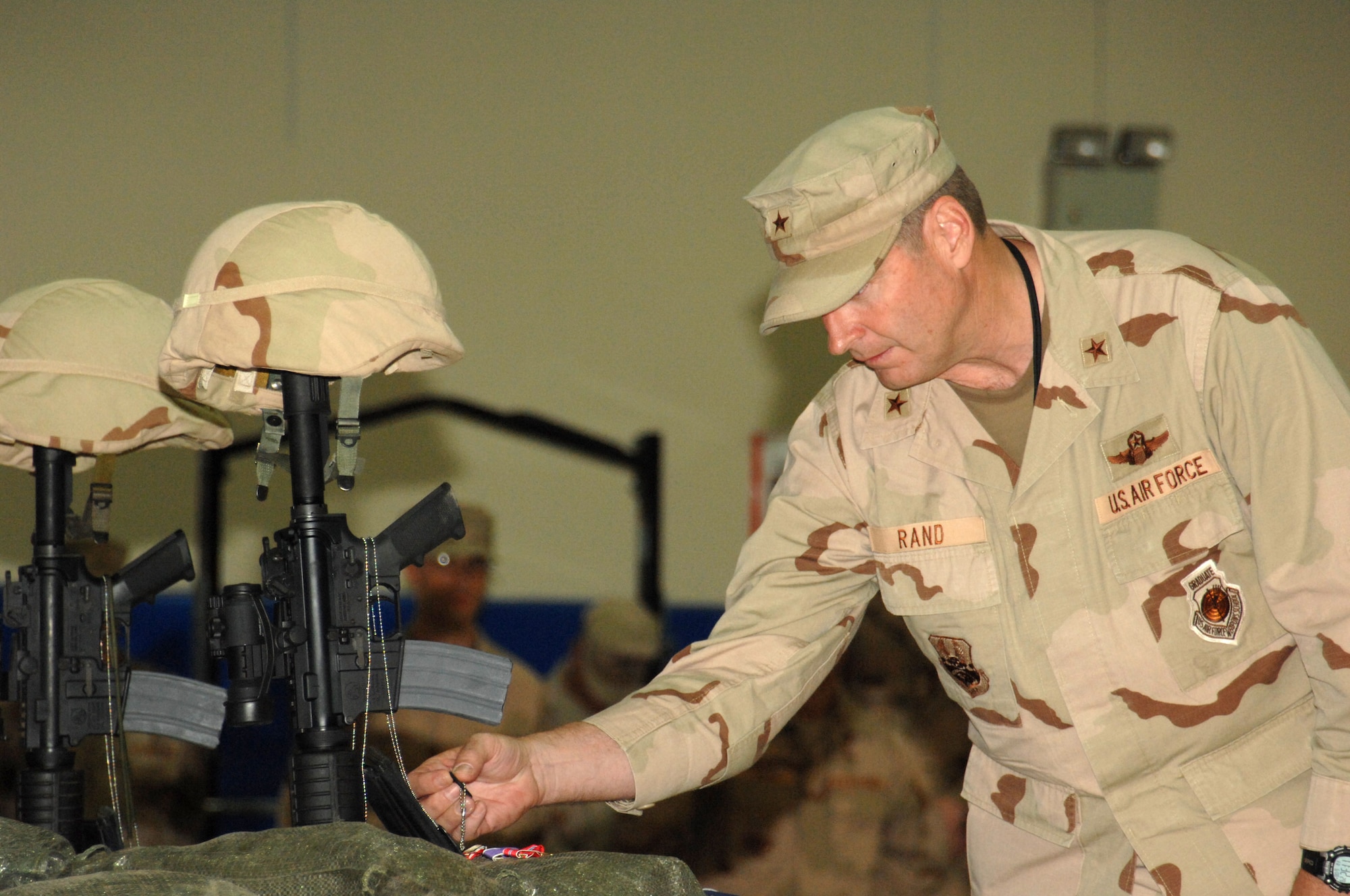 Brig. Gen. Robin Rand, 332nd Air Expeditionary Wing commander at Balad Air Base, Iraq, pays his respects during a memorial ceremony June 8 honoring Special Agents Tech. Sgt. Ryan Balmer and Staff Sgt. Matthew Kuglics at Kirkuk Regional Air Base, Iraq. The agents were killed in action June 5 while supporting Operation Iraqi Freedom. (U.S. Air Force photo/ Senior Airman Kristin Ruleau)