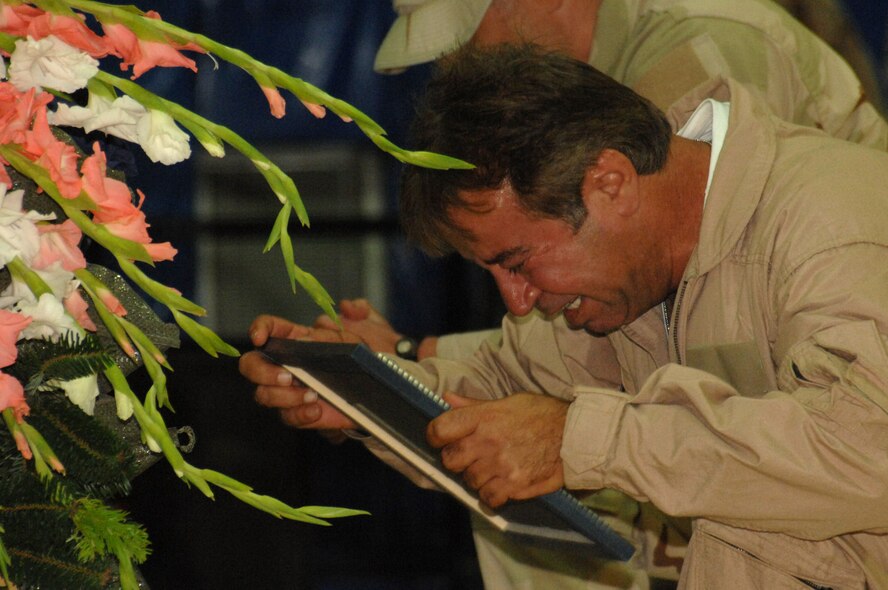 An interpreter for Air Force Office of Special Investigations Expeditionary Detachment 2410 grieves during a memorial ceremony June 8 honoring Special Agents Tech. Sgt. Ryan Balmer and Staff Sgt. Matthew Kuglics at Kirkuk Regional Air Base, Iraq. The agents were killed in action June 5 while supporting Operation Iraqi Freedom. (U.S. Air Force photo/ Senior Airman Kristin Ruleau)