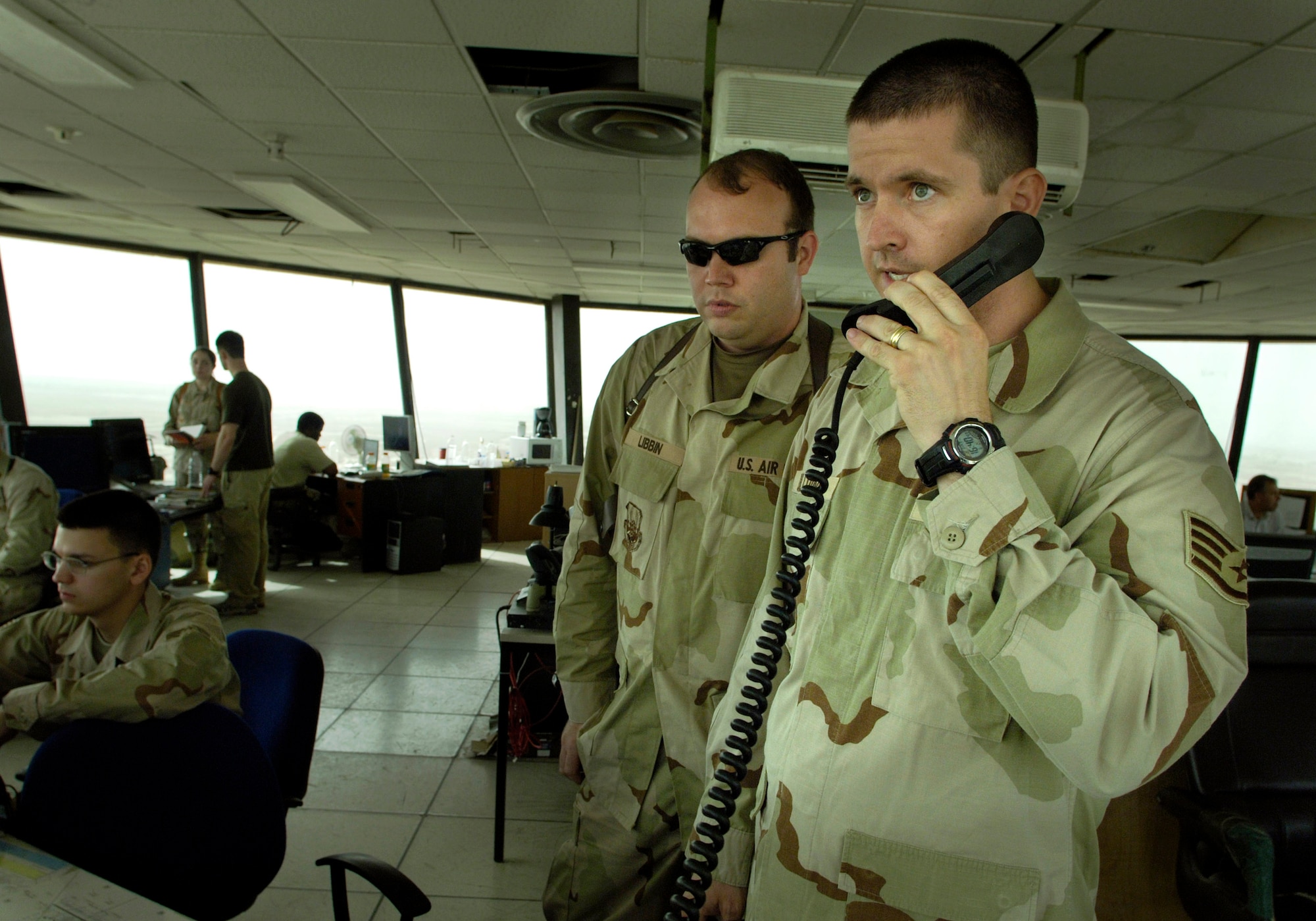 Air traffic controller Staff Sgt. Troy Dilldine manages one of the more than 14,000 aircraft per month currently flying into and out of Baghdad International Airport June 2, as Tech. Sgt. Kenneth Libbin observes.  .  In addition to manning the control tower and improving the infrastructure and technology in the tower, Air Force controllers are working with Iraqi controllers in an effort to speed the transition from U.S. to Iraqi control of airspace.  Sergeant Libbon is deployed from Moron Air Base, Spain, and Sergeant Dilldine is deployed from Incirlik AB, Turkey.  (U.S. Air Force photo/Master Sgt. Jim Varhegyi)