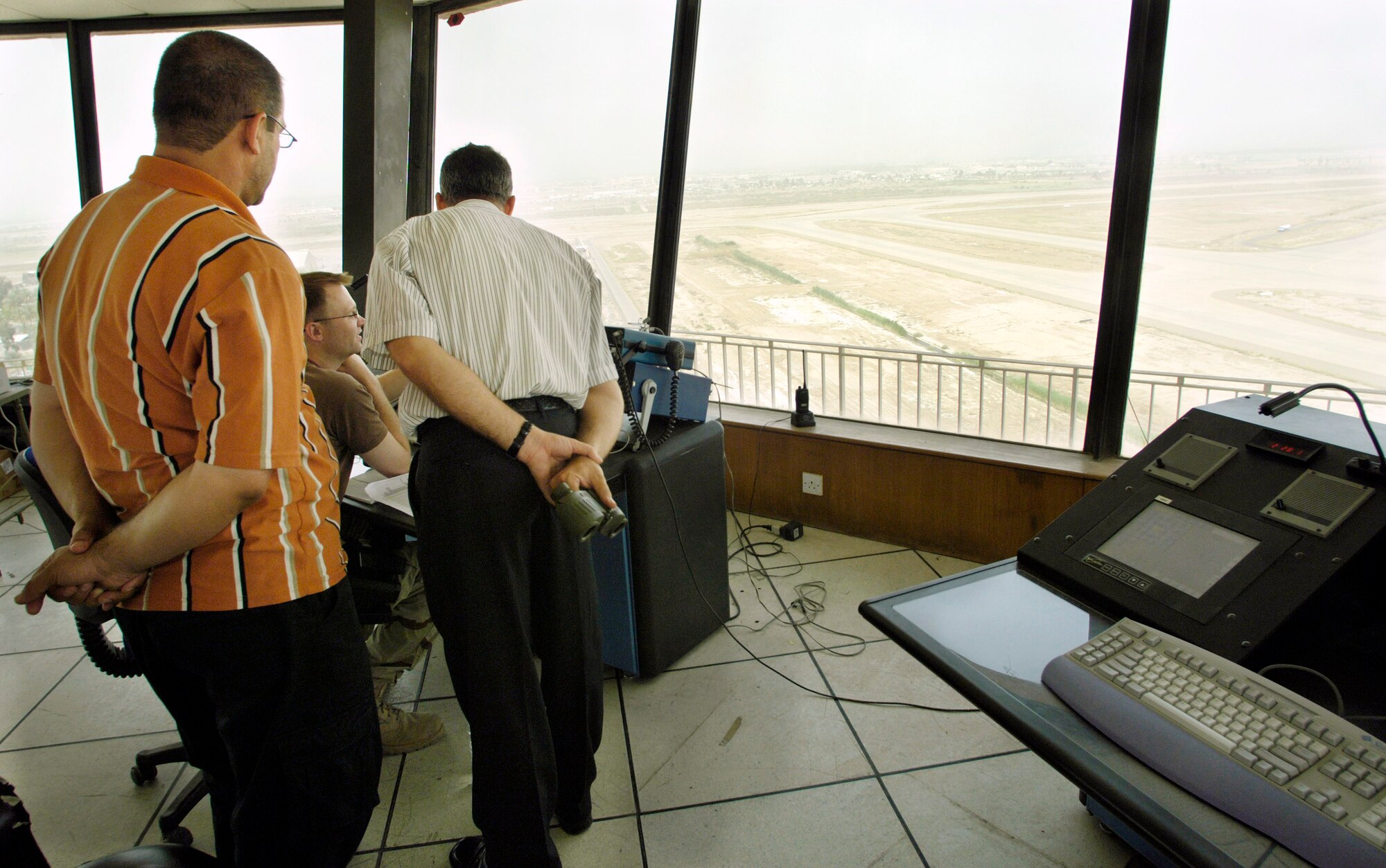 Staff Sgt. William Ferguson (seated at console) explains parking procedures for international flights coming into the Baghdad International Airport to Iraqi air traffic controllers June 2.  In addition to manning the control tower and improving the infrastructure and technology in the tower, Air Force controllers are working with Iraqi controllers in an effort to speed the transition from U.S. to Iraqi control of airspace.  Sergeant Ferguson is deployed from the Wyoming Air National Guard in Casper, Wyo.  (U.S. Air Force photo/Master Sgt. Jim Varhegyi)