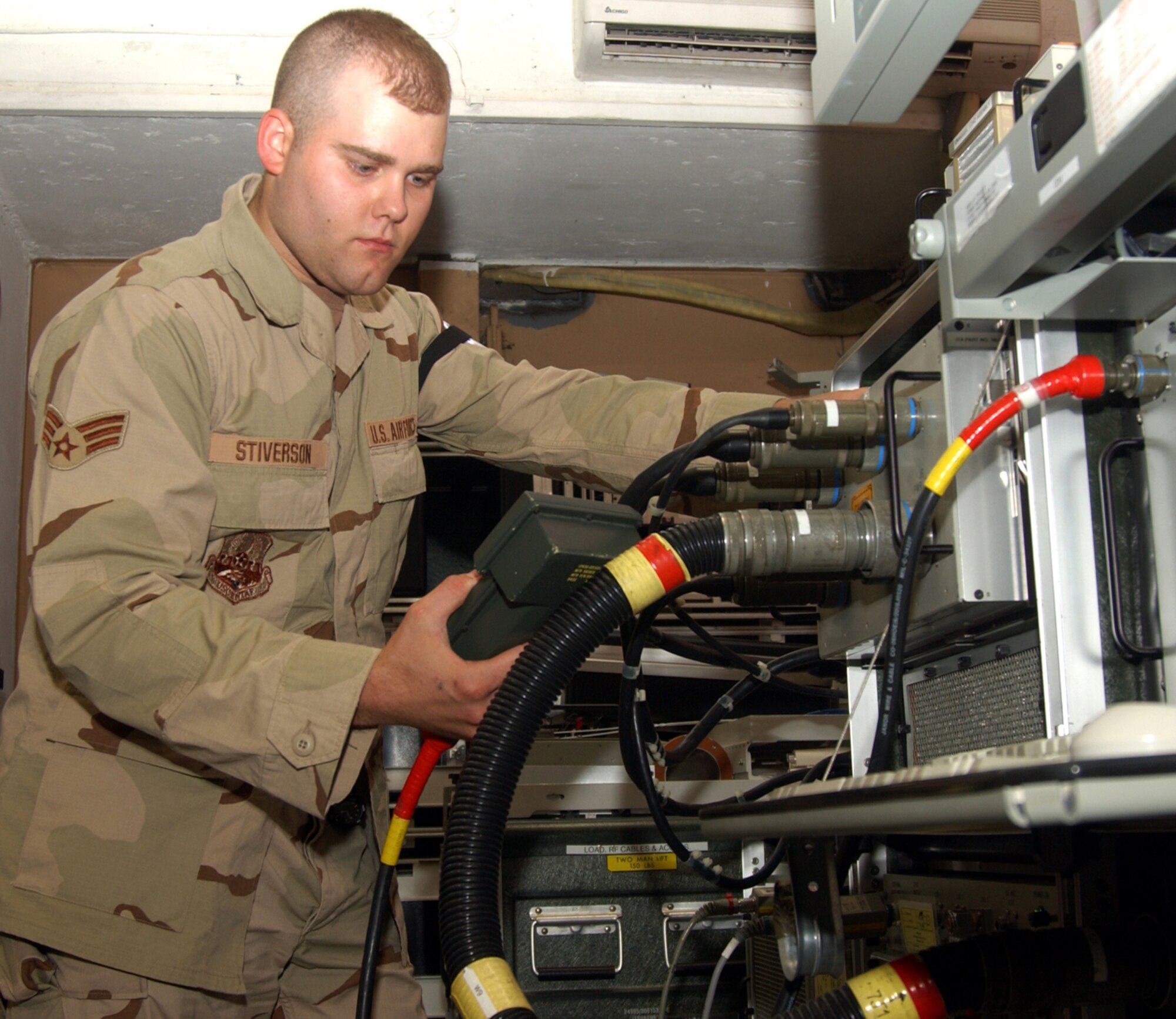 BALAD AIR BASE, Iraq -- Senior Airman Clinton Stiverson, Avionics Intermediate Shop technician, uses a hand-held terminal to control the test program. The HHT is used for manual intervention. It can be used when the keyboard is not accessible and to read information that is on the station monitor such as voltage readings and various other measurements.