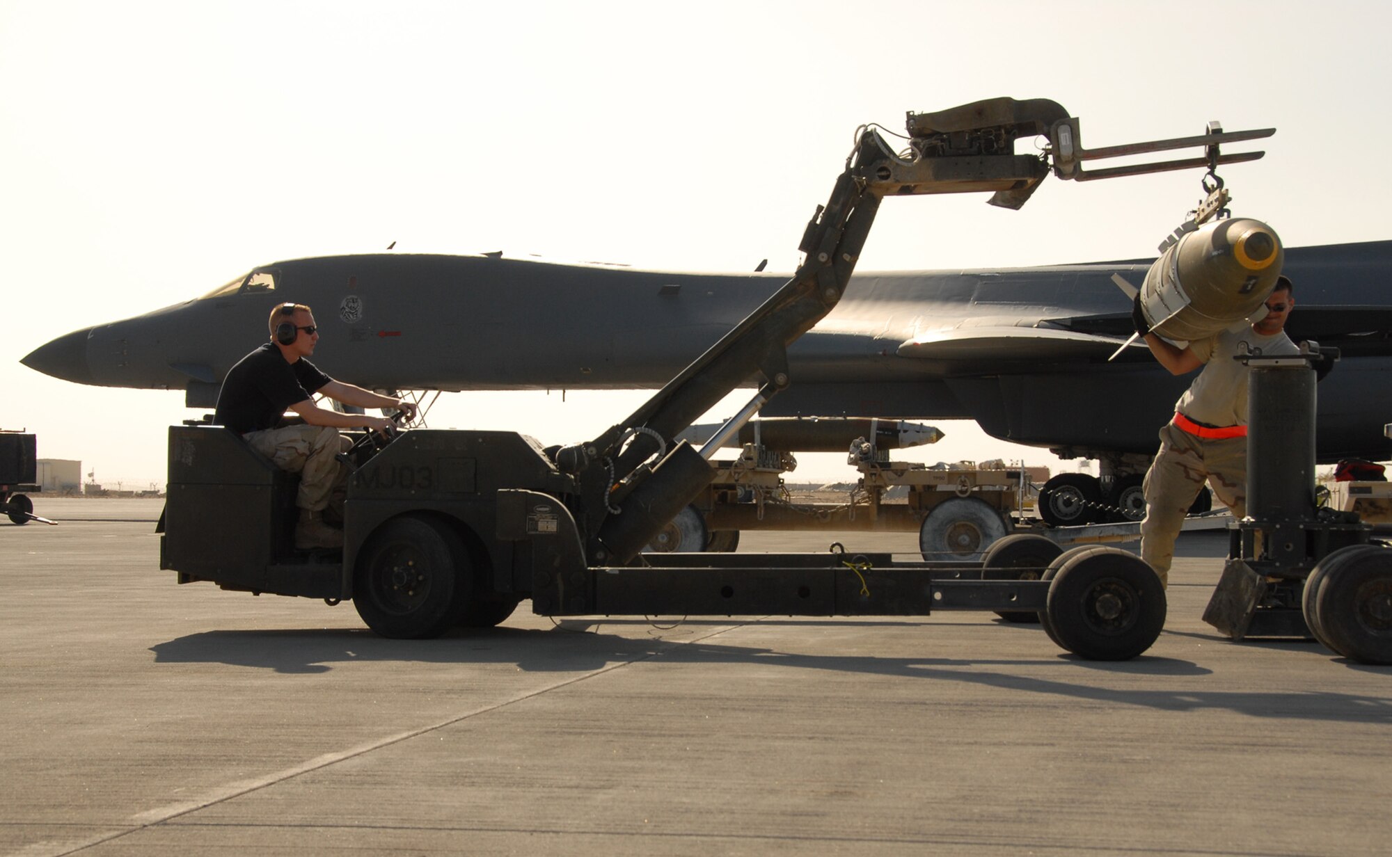 Air Force bomb loaders position a guided bomb unit-31 to be loaded on an Air Force B-1B Lancer at a base in Southwest Asia. B-1s fly close-air-support missions for both Operation Enduring and Iraqi Freedom. (U.S. Air Force photo.)