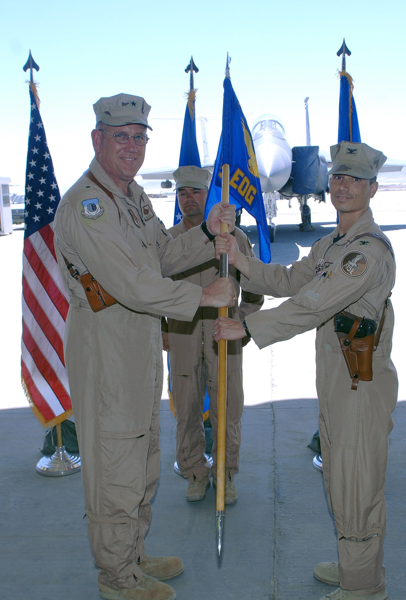 Col. John Quintas (right), 455th Expeditionary Operations Group outgoing commander, relinquishes the group guidon to Brig. Gen. Bill Hyatt, 455th Air Expeditionary Wing commander, signifying a change in command for the group. (photo by Staff Sgt. Craig Seals)