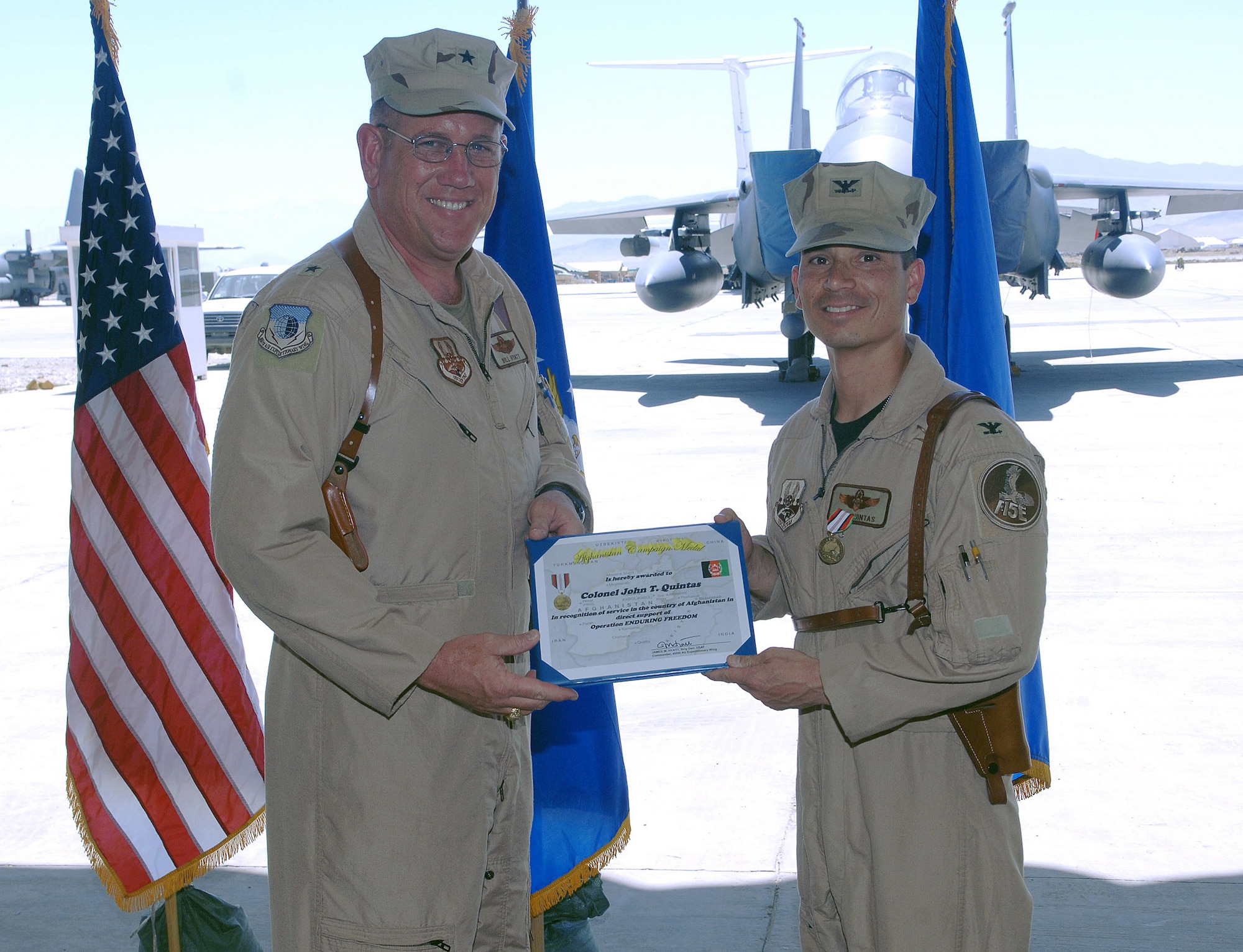 Brig. Gen. Bill Hyatt (left), 455th Air Expeditionary Wing commander, presents Col. John Quintas, 455th Expeditionary Operations Group outgoing commander, with the Afghanistan Campaign Medal at the operations group change-of-command ceremony at Bagram Airfield, Afghanistan June 11. (photo by Staff Sgt. Craig Seals)