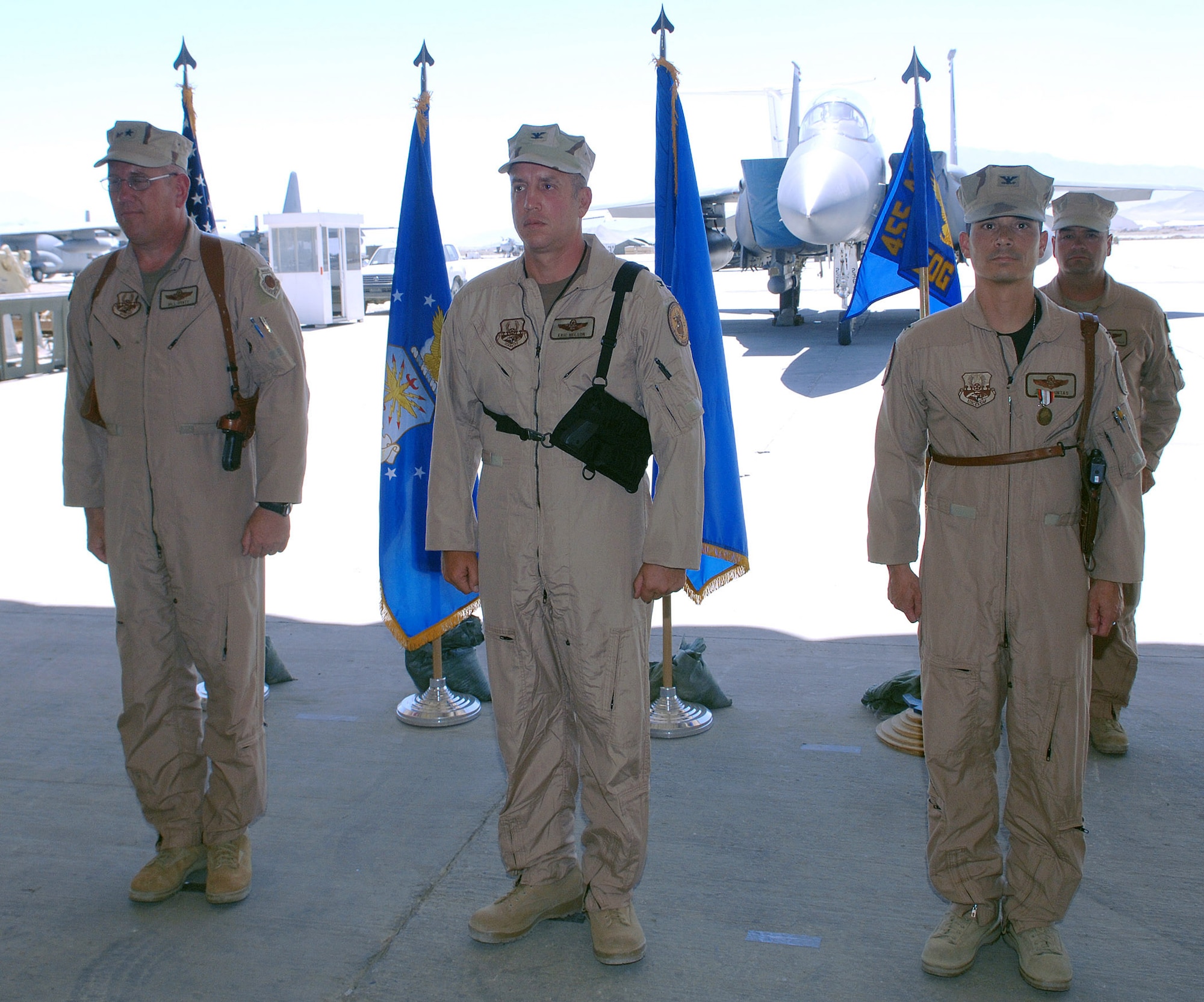 (From left to right) Brig. Gen. Bill Hyatt, 455th Air Expeditionary Wing commander, Col. Eric Nelson, 455th Expeditionary Operations Group commander, and Col. John Quintas, 455th EOG outgoing commander, stand at attention during the operations group change-of-command ceremony at Bagram Airfield, Afghanistan June 11. Col. Quintas relinquished command of the group to Col. Nelson, the new commander. (photo by Staff Sgt. Craig Seals)