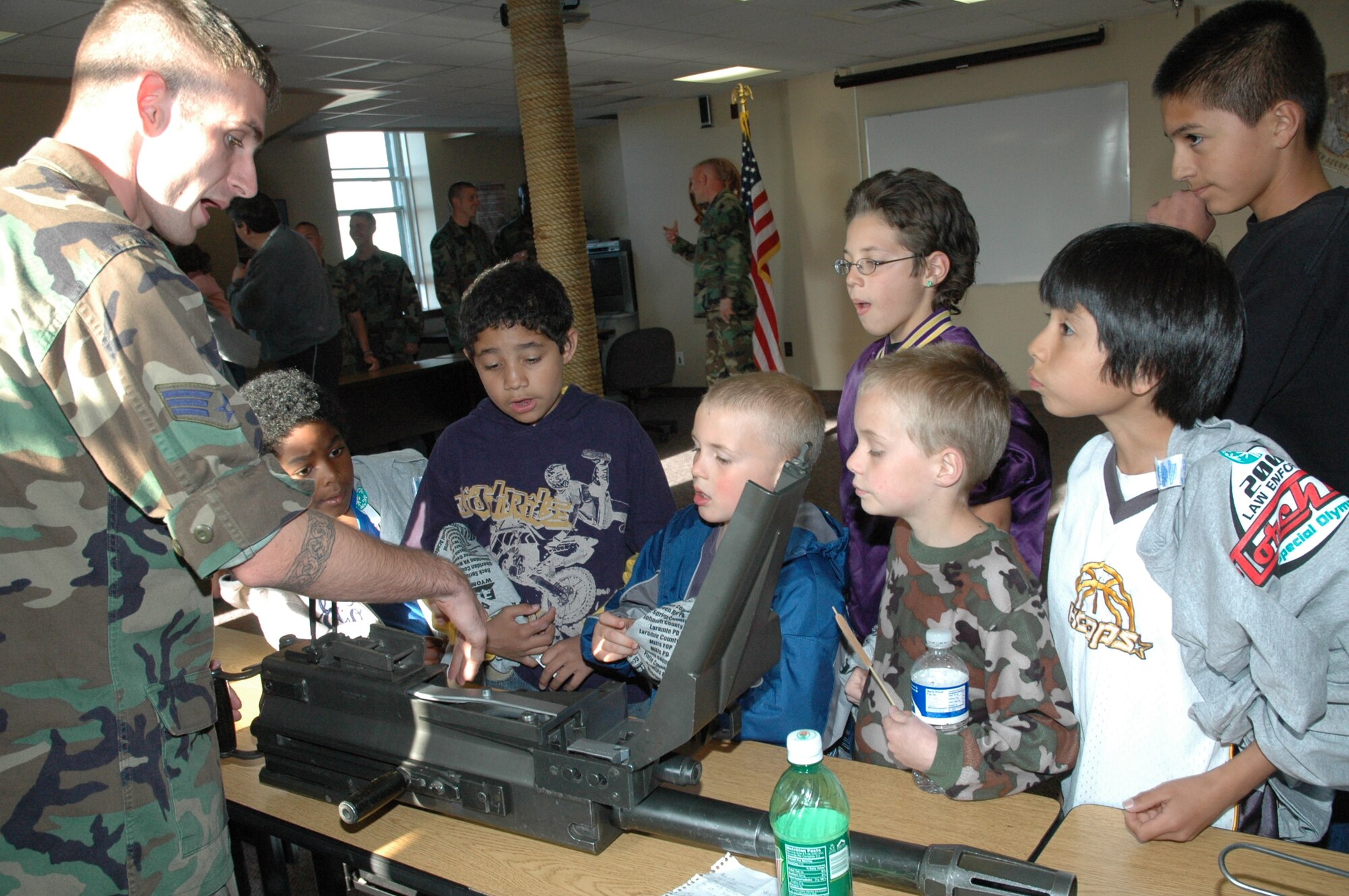 Senior Airman Joseph Wilson, 90th Security Forces Squadron, shows the functions of different weapons to children of the Special Friends Youth Alternative Program May 31. Members of flight four of the 90th MSFS helped with the demonstrations that included self defense tactics, police K-9s and camouflage face painting (Photo by Airman Alex Martinez).