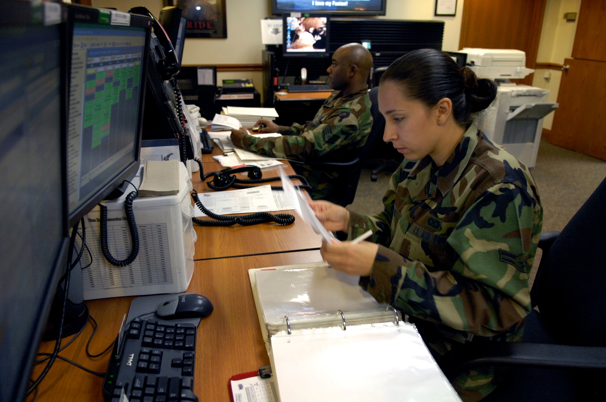 Airman 1st Class Brenda Davis and Staff Sgt. Lynn Brown work at their control consoles inside the command post at Hickam Air Force Base, Hawaii 8 June 2007. The Airmen are emergency actions controllers from the 15th Airlift Wing. (U.S. Air Force photo/ Tech. Sgt. Shane A. Cuomo)