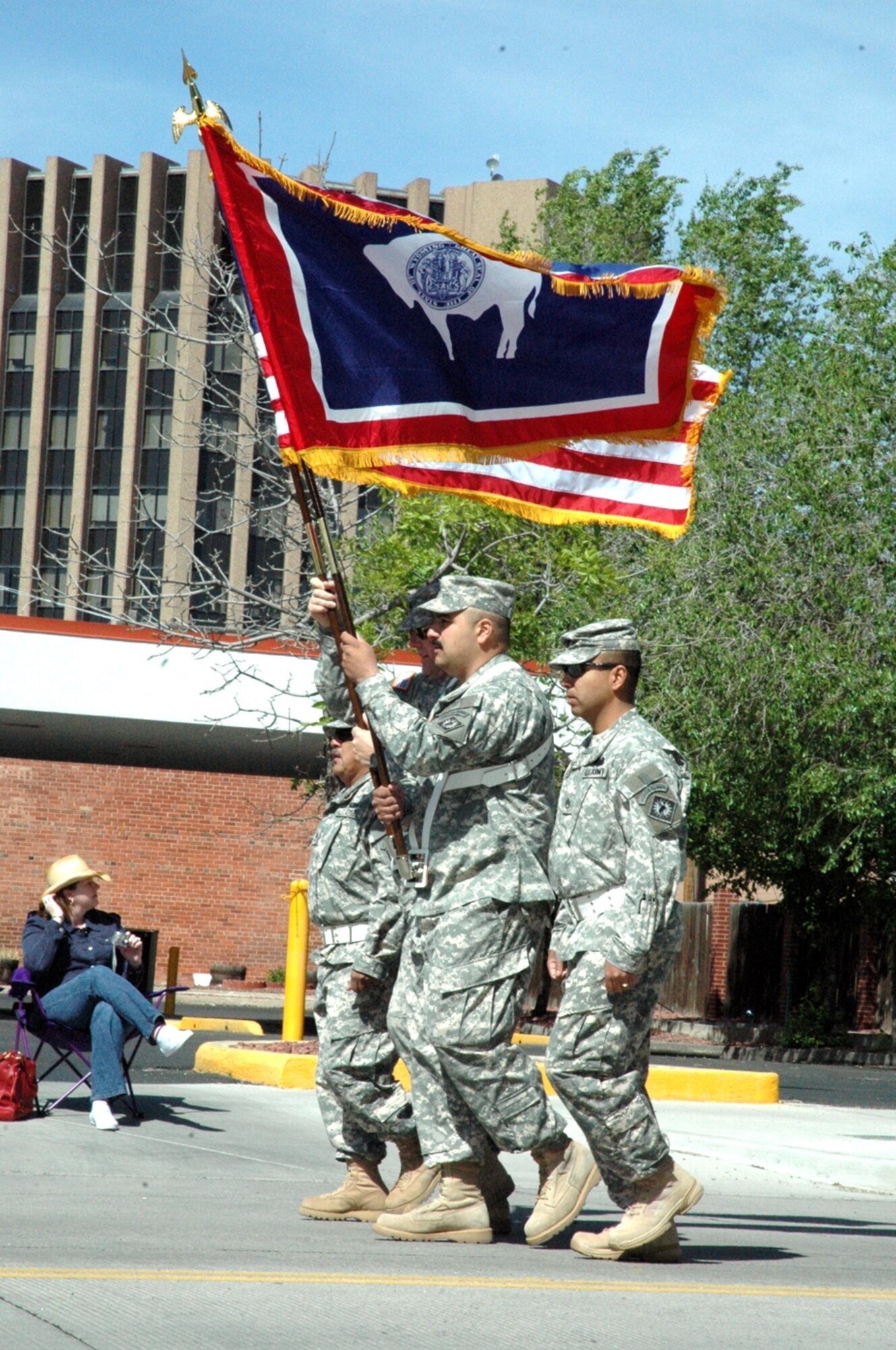 Troops from the Wyoming National Guard march with flags during the Cheyenne Memorial Day Parade (Photo by Airman Alex Martinez).