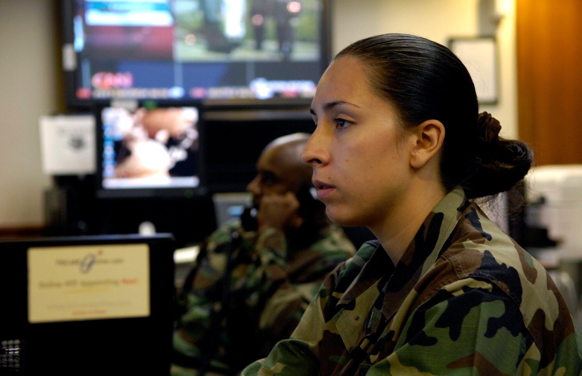 Airman 1st Class Brenda Davis and Staff Sgt. Lynn Brown work at their control consoles inside the command post at Hickam Air Force Base, Hawaii 8 June 2007. The Airmen are emergency actions controllers from the 15th Airlift Wing. (U.S. Air Force photo/ Tech. Sgt. Shane A. Cuomo)