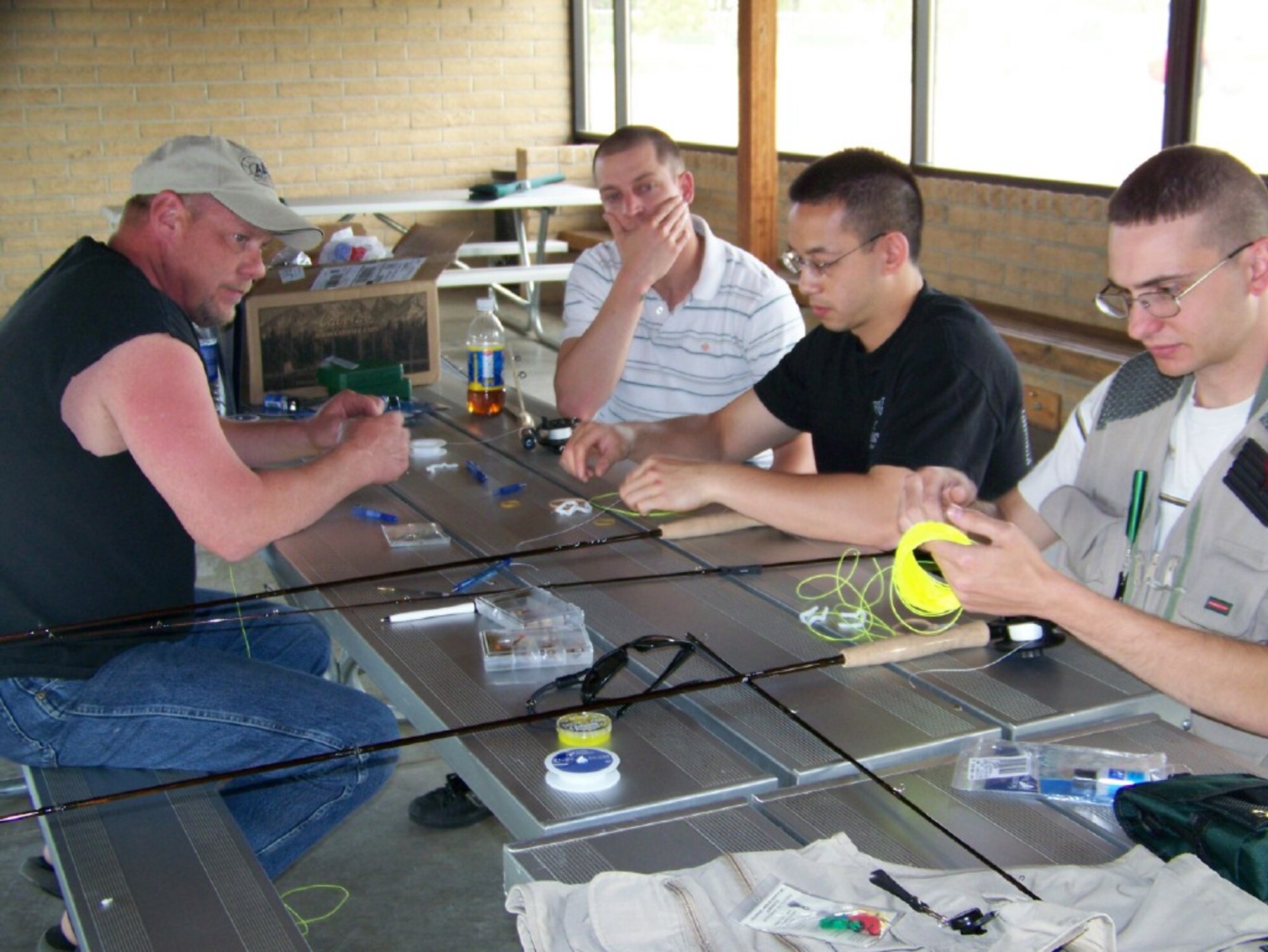Garry Carpenter teaches fishing-hopefuls Staff Sgt. Ben Lineberger, 90th Missile Maintenance Squadron; Senior Airman Jaylon Sybert, 90th Medical Operations Squadron; and Airman 1st Class Tommy Vinh, 90th MDOS, the fundamentals of fly fishing during a fly fishing instructing clinic May 16. For information on the next Fly Fishing Clinic June 20, call outdoor recreation at 773-2988 (Photo by Terri Ammons).