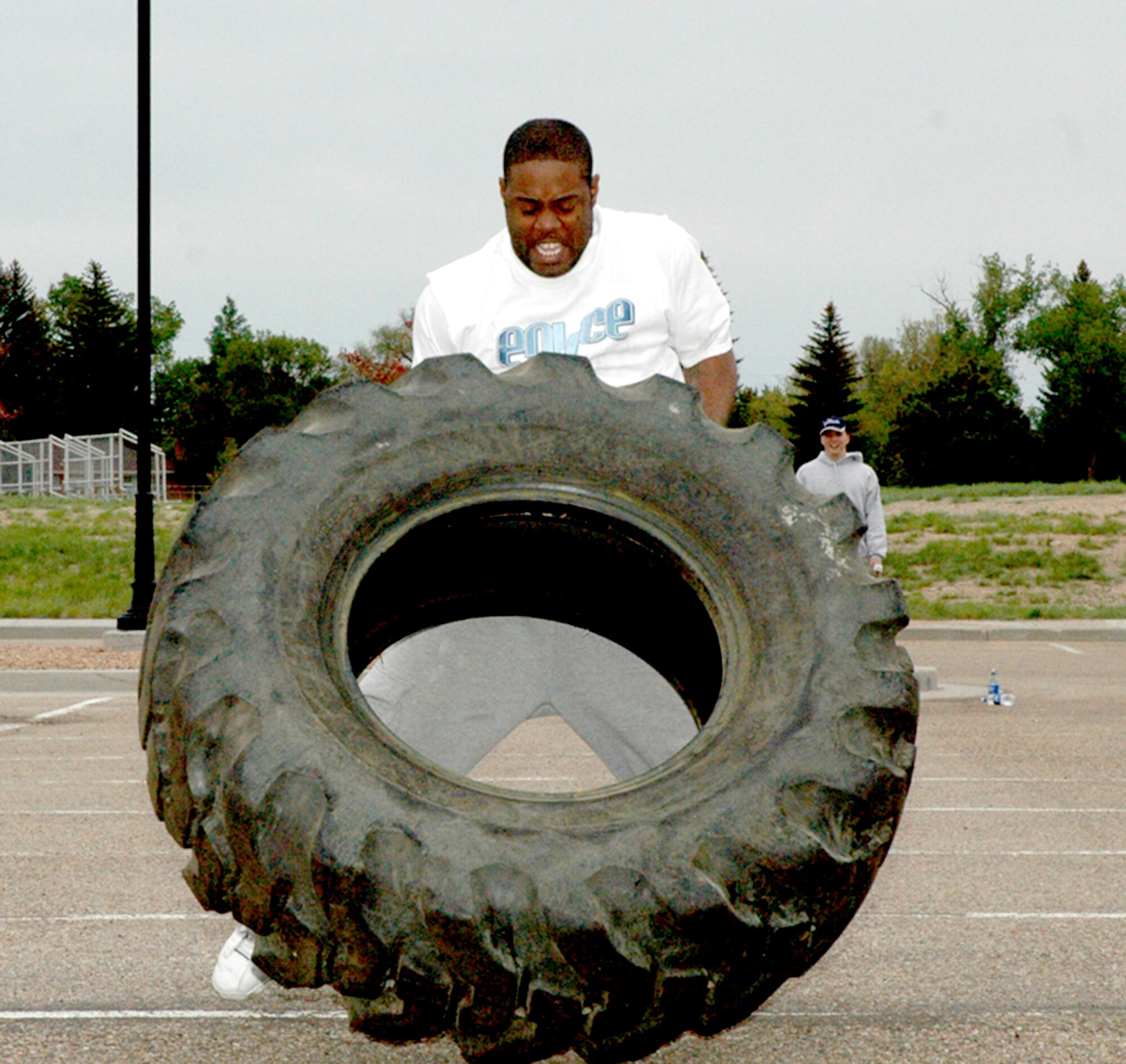Staff Sgt. Ricardo Hollingsworth, 90th Missile Maintenance Squadron, flips a tire toward the finish line during the strongman competition at the base gym May 23. The tire flip was one of five challenges in this competition. The competition was the last event of May Fitness Month (Photo by Airman 1st Class Daryl Knee).