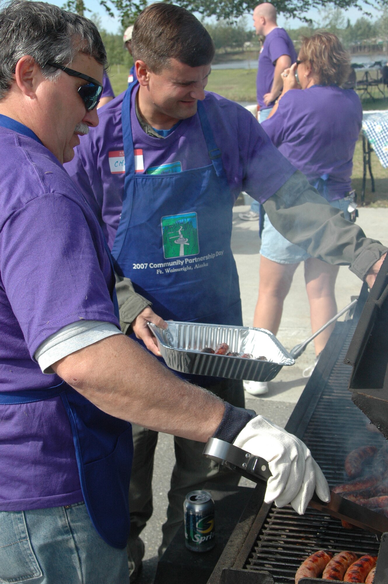 EIELSON AIR FORCE BASE, Alaska--Col. Chip Thompson (back), 354th Operations Group commander, cooks lunch for Community Partnership Day volunteers June 8 at Fort Wainwright.  Eielson AFB and Fort Wainwright leadership and civic leaders serve volunteers as "celebrity chefs" each year. (U.S. Air Force photo by 1st Lt. Bryon McGarry)

