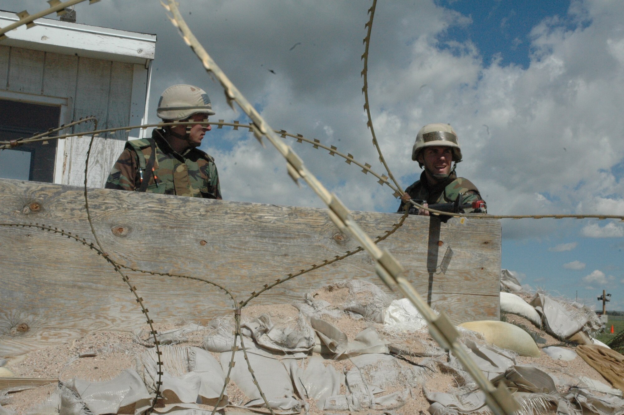 Airman 1st Class Logan Parsons, 90th Logistics Readiness Squadron, and Senior Airman Matthew Davis, 90th LRS, guard the main gate to the Field Warrior Exercise held here May 21-24.