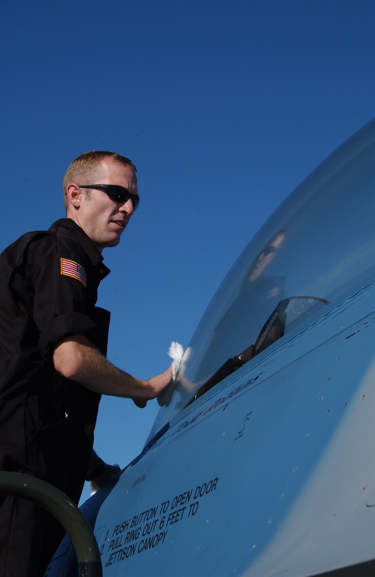 EIELSON AIR FORCE BASE, Alaska --  Senior Airman Jed Winkelman, 64th Aggressor Squadron, Nellis Air Force Base, Nev., cleans the canopy of an F-16 June 8. Airman Winkelman is one of many crew chiefs from around the Air Force who came to participate in Red Flag 07-02, which runs through June 15.  (U.S. Air Force photo by Airman 1st Class Christopher Griffin)