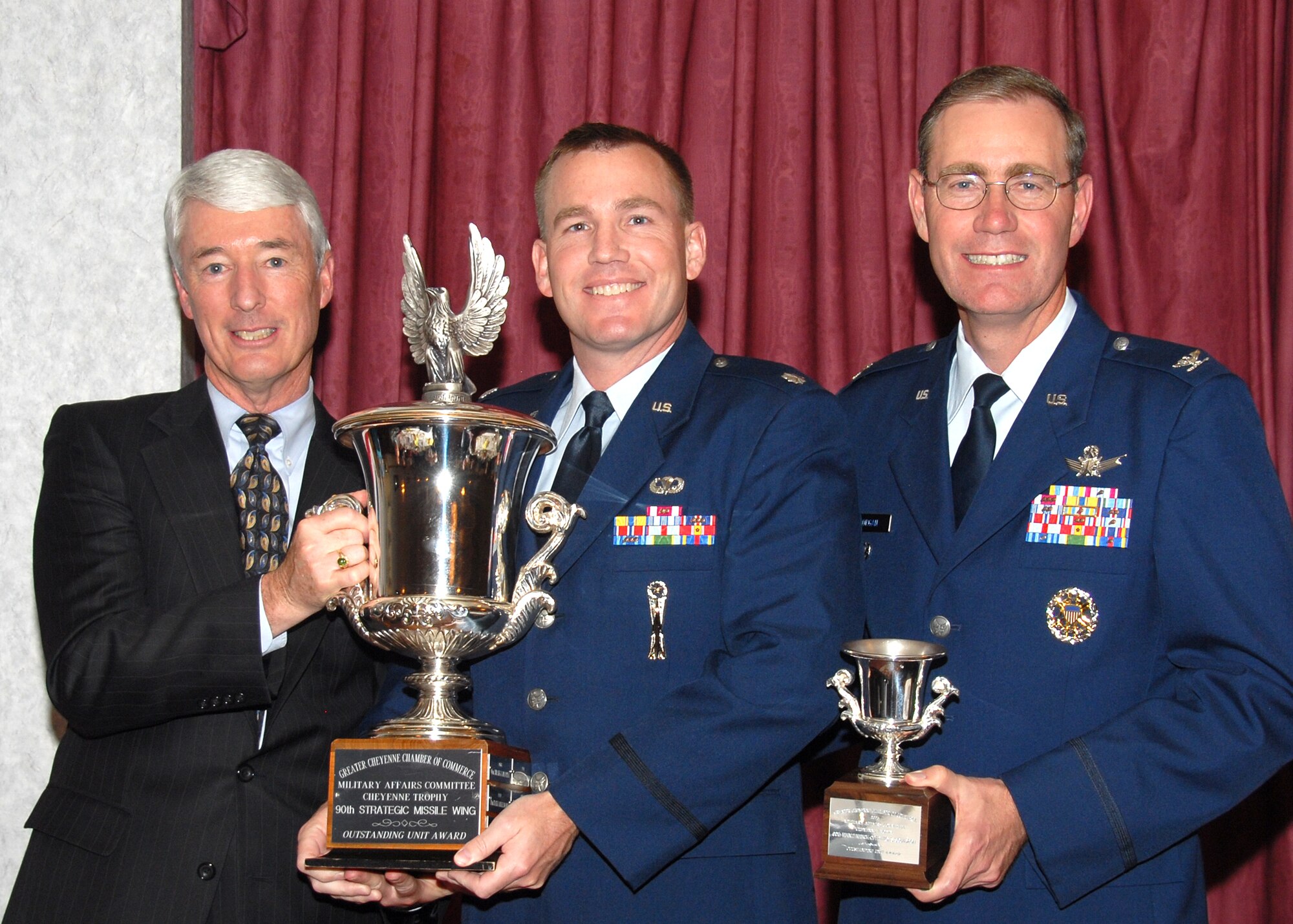 Col. Michael Morgan, 90th Space Wing vice commander, Lt. Col. Joel Hanson, 90th Maintenance Operations Squadron commander and Joe Mulcahy, Military Affairs Committee chairman, present the 2006 Cheyenne Trophy recognizing the 90th MOS as the 90th Space Wing’s most outstanding unit. Some 90th MOS achievements in the past year include top results during the three higher headquarters inspections, two Air Force Space Command- level awards, 73 tours and many volunteer hours toward numerous charity activities (Photo by Rob Watkins).