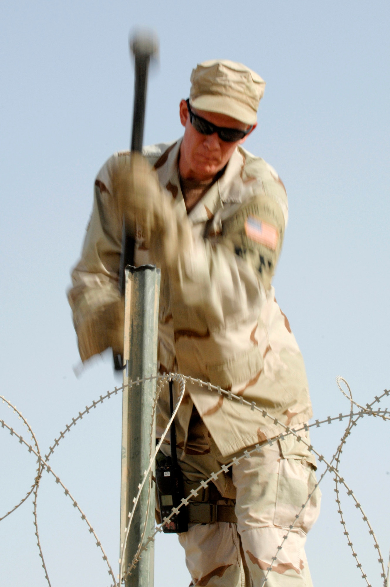 Tech. Sgt. Hunter Lescoe pounds a stake in while installing concertina wire on a wall to protect one of the compounds on Ali Air Base, Iraq. Sergeant Lescoe is a member of the 407th Expeditionary Security Forces Squadron's Force Protection Flight. The flight is responsible for monitoring local and third country nationals to detect suspicious activity, augmenting security forces during increased threat levels, as well as monitoring and maintaining installation security measures. (U.S. Air Force photo/Master Sgt. Robert W. Valenca)