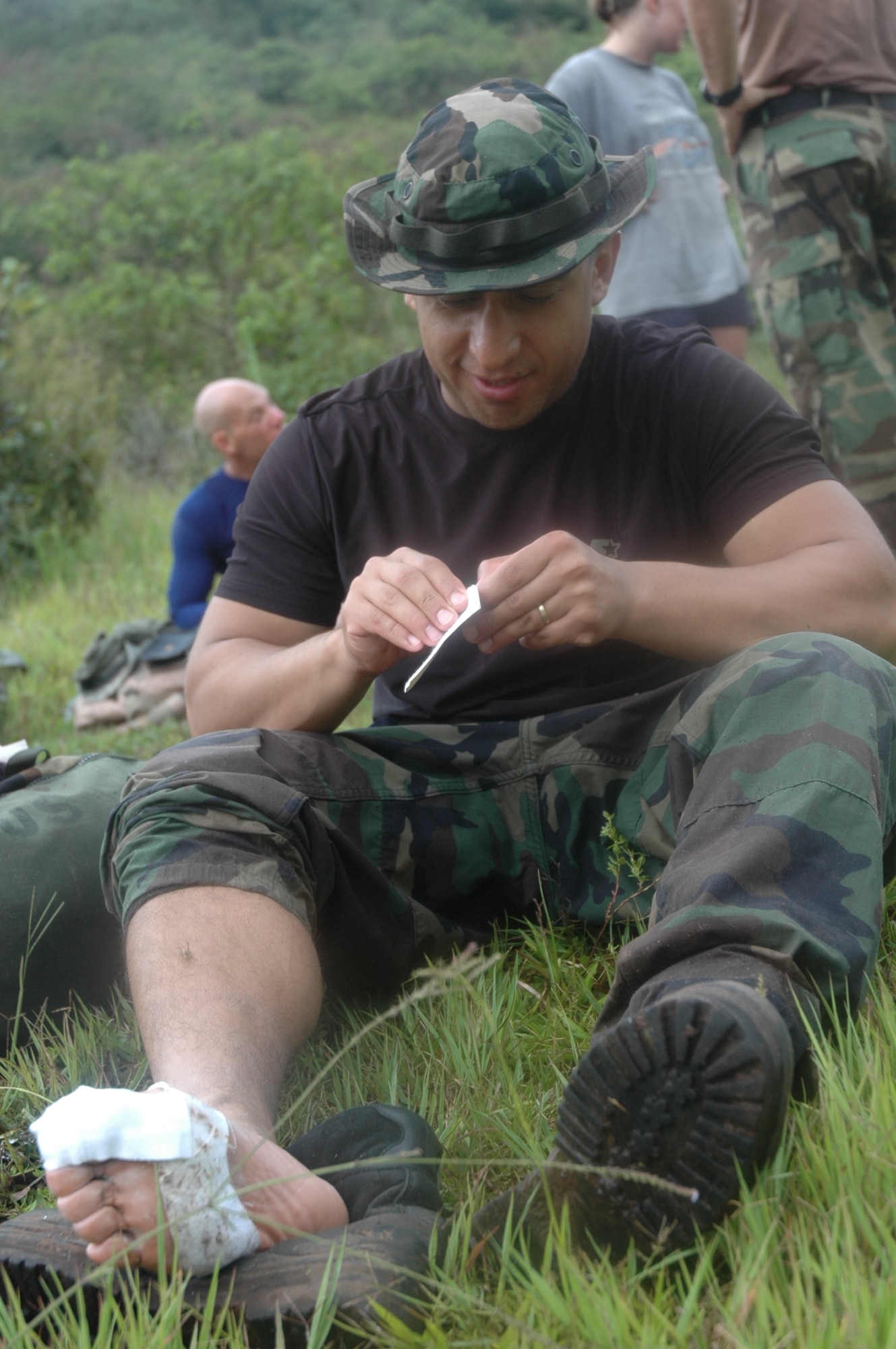 Air Force Staff Sgt. Enrique Castro, Joint Security Forces, tends to his feet  on the first day of the two-day march from Tamara, Honduras to Soto Cano Air Base. The march officially named "The Iguana Challenge" was a command directed volunteer march for members of Joint Task Force-Bravo and Honduran Military members. The 30-mile march took particpants over the mountains surrouding Soto Cano AB. 