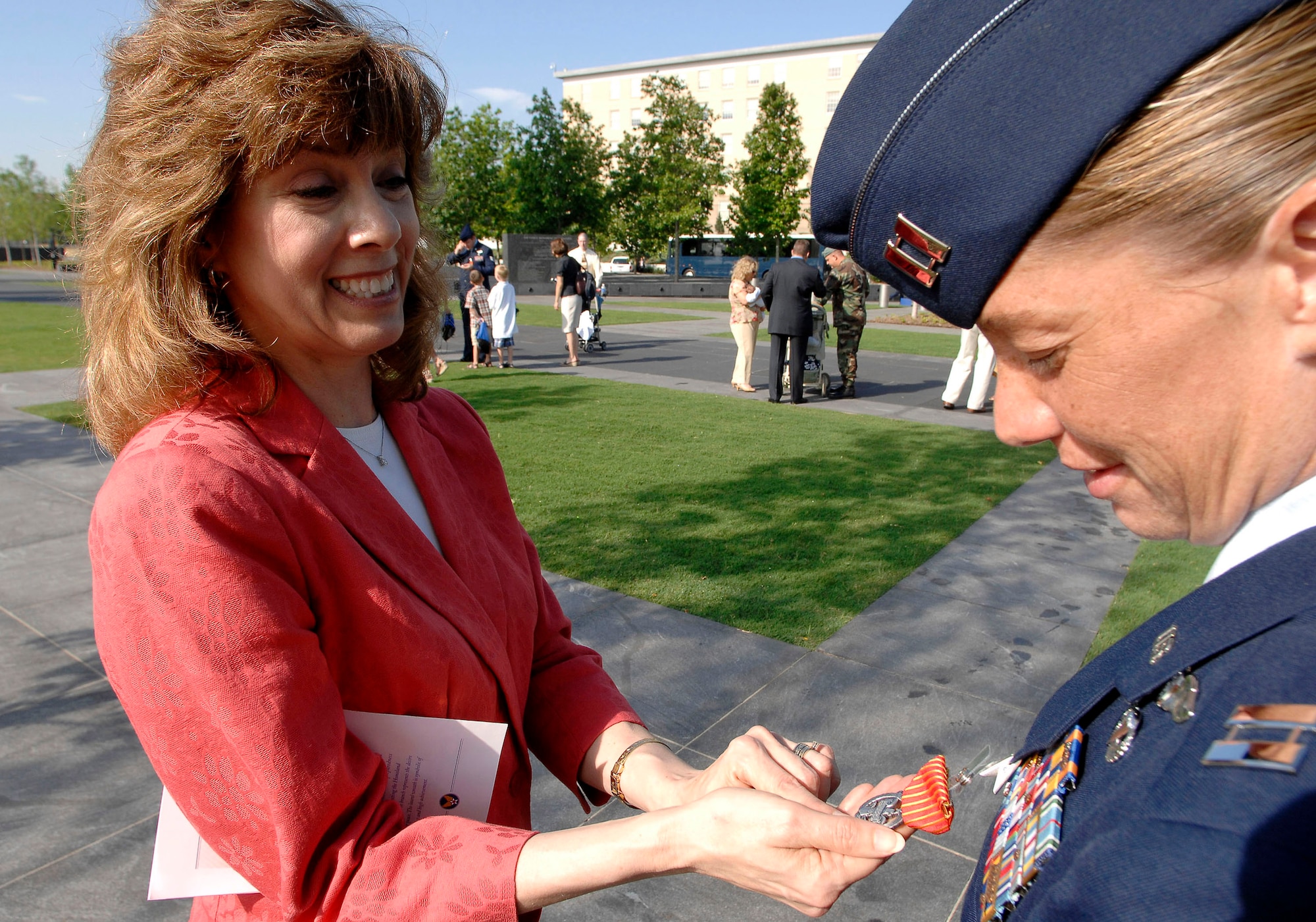 Susan Gamble, designer of the Air Force Combat Action Medal, looks at her work after one of the medals was pinned on Capt. Allison Black, 1st Special Operations Group, Hurlburt Field, Fla. The captain was one of the first six Airmen to receive the medal in a ceremony June 12 at the Air Force Memorial in Arlington, Va. (U.S. Air Force photo/Staff Sgt. Brian Ferguson)