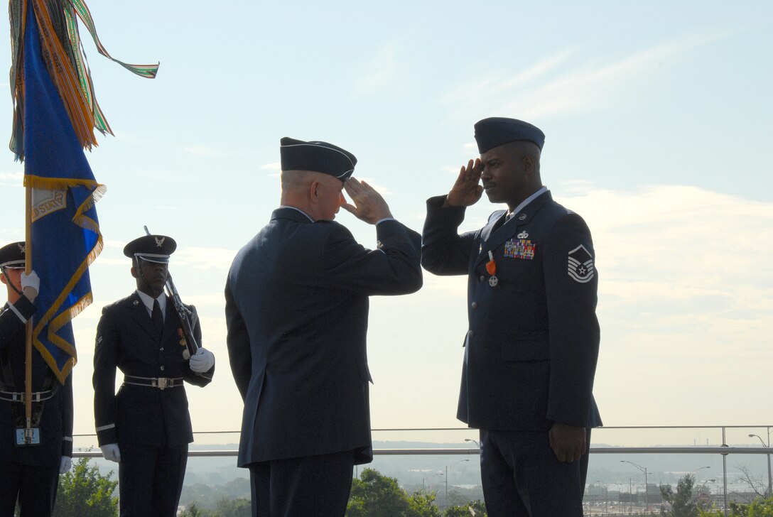 ARLINGTON, Va. -- Chief of Staff of the Air Force Gen. T. Michael Moseley presents the Air Force Combat Action Medal to Master Sgt. Charlie Peterson, who received the medal for heroic actions while deployed on convoy duty in 2004.  The medal was presented for the first time to six Airmen at the ceremony held at the Air Force Memorial today.