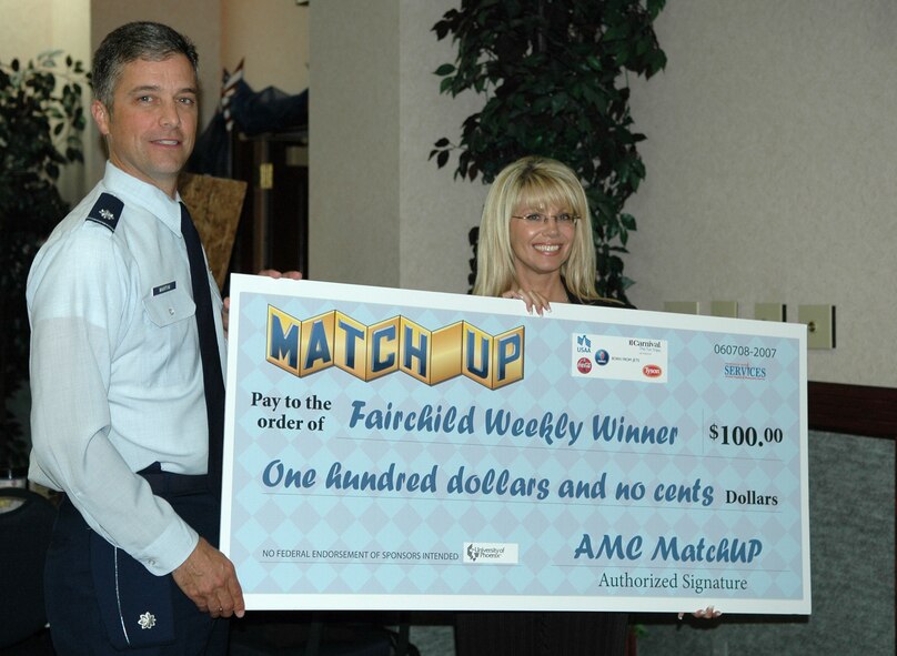 FAIRCHILD AIR FORCE BASE, Wash. – Michelle McGuire, a representative from the University of Phoenix, presents Lt. Col. Earl Martin with an over-sized $100 check. Colonel Martin won a drawing at Fairchild’s Law Day June 8. (U.S. Air Force photo/ Airman 1st Class Kali L. Gradishar)