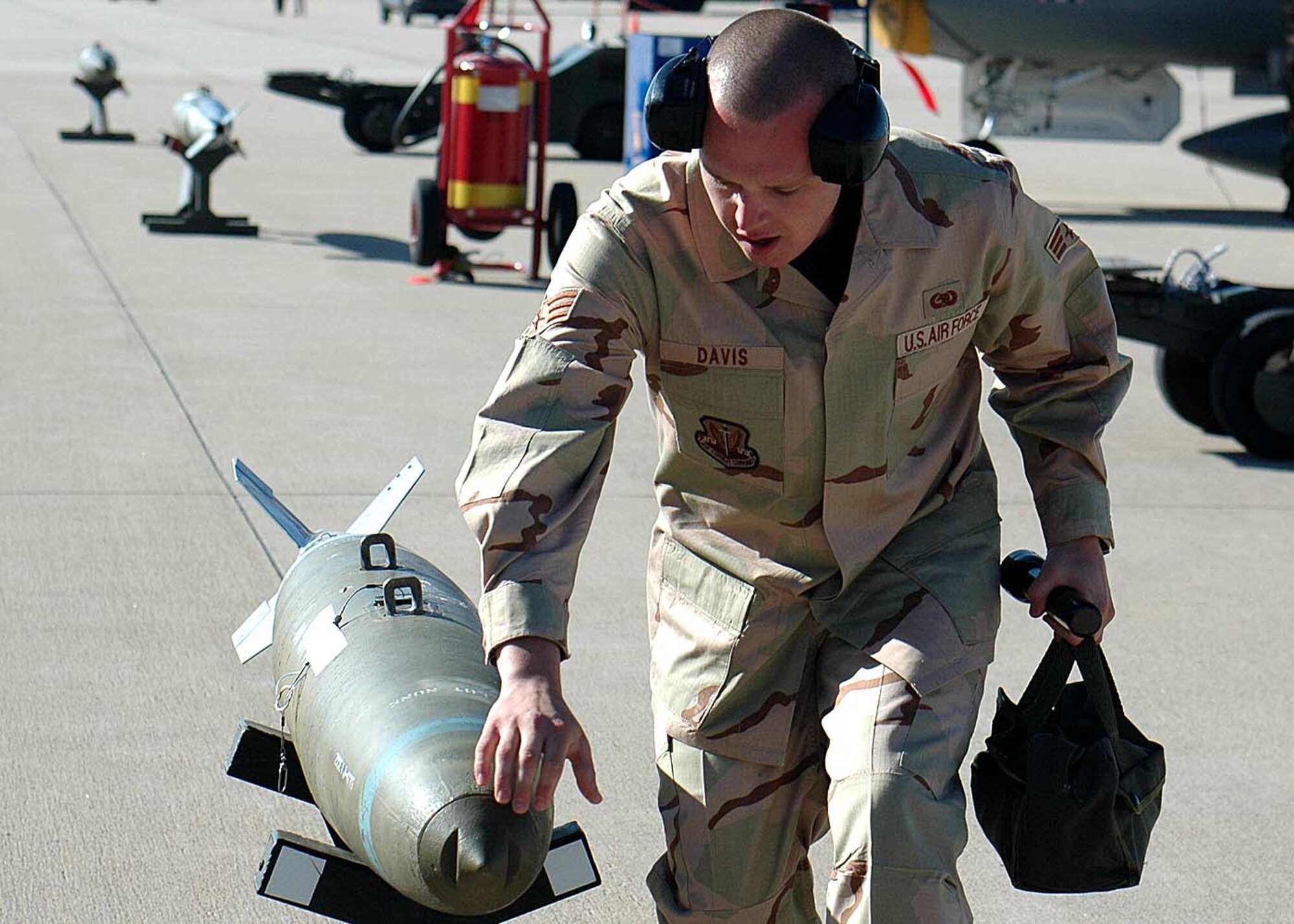 Senior Airman Zacariah Davis, 49th Aircraft Maintenance Squadron, looks over the bomb to be loaded during the weapons load competition at Cannon Air Force Base, N.M. Twenty five Airmen traveled to Cannon for the Pioneer Air Festival where the team took first place with a weapons load competition and bomb drop demonstration. (U.S. Air Force photo/Airman 1st Class Heather Stanton)