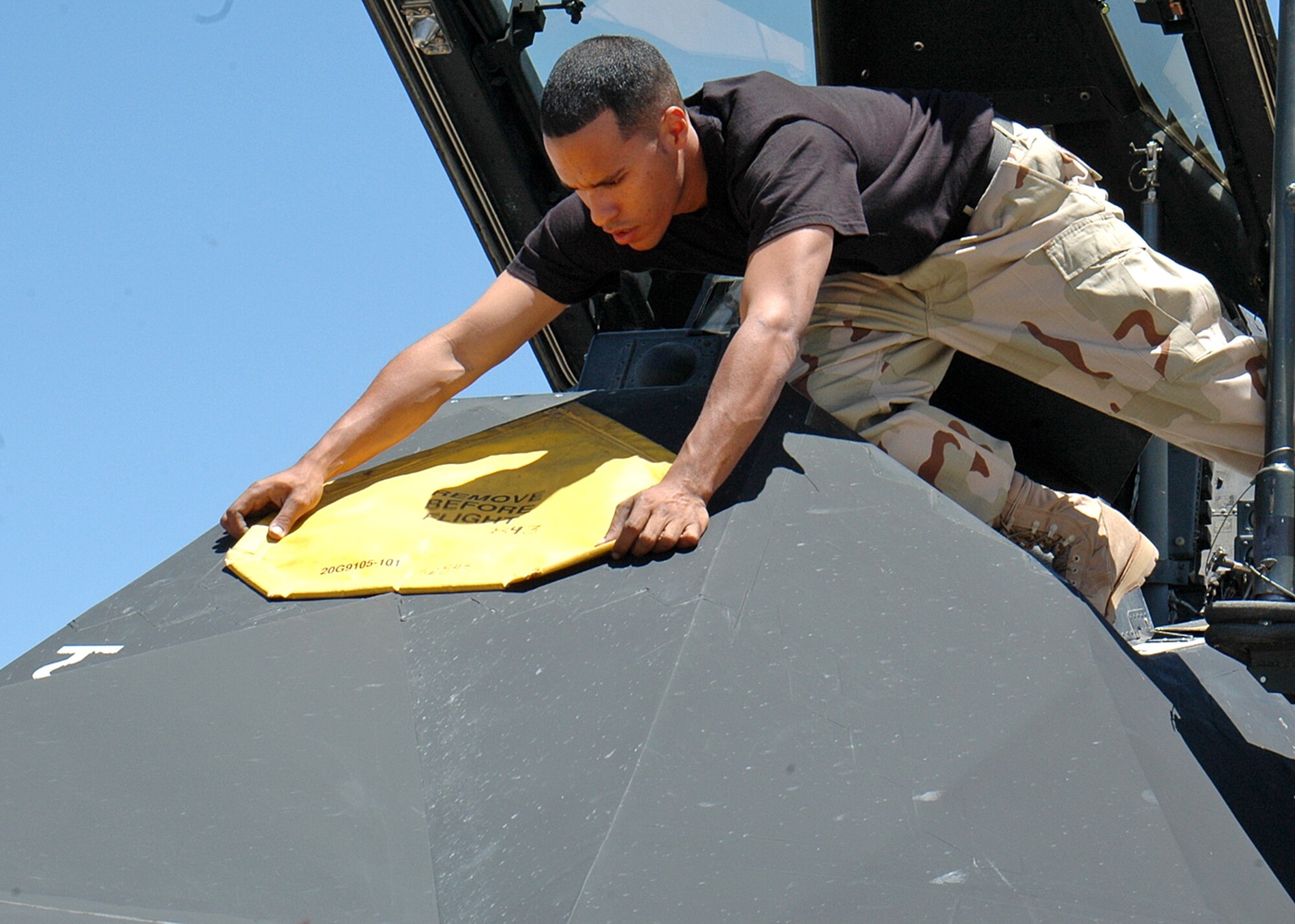 Airman 1st Class Raphael Gerena, 49th Aircraft Maintenance Squadron, places a protective cover on the F-117A after three Nighthawks landed at Cannon Air Force Base, N.M. Twenty five Airmen traveled to Cannon for the Pioneer Air Festival where the team took first place with a weapons load competition and bomb drop demonstration. (U.S. Air Force photo/Airman 1st Class Heather Stanton)