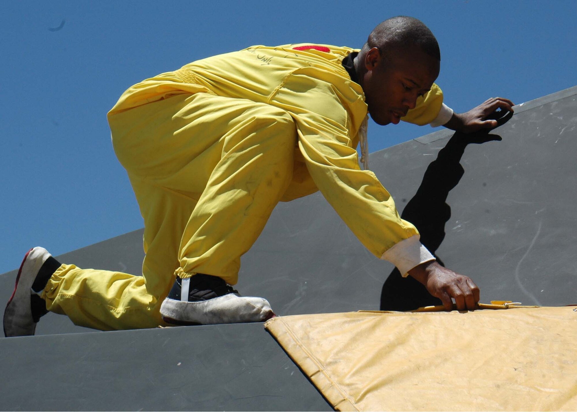Staff Sgt. Ernest Evans, 49th Aircraft Maintenance Squadron, place covers over the black F-117A for protection at Cannon Air Force Base, N.M., after three Nighthawks landed. Twenty five Airmen traveled to Cannon for the Pioneer Air Festival where the team took first place with a weapons load competition and bomb drop demonstration. (U.S. Air Force photo/Airman 1st Class Heather Stanton)